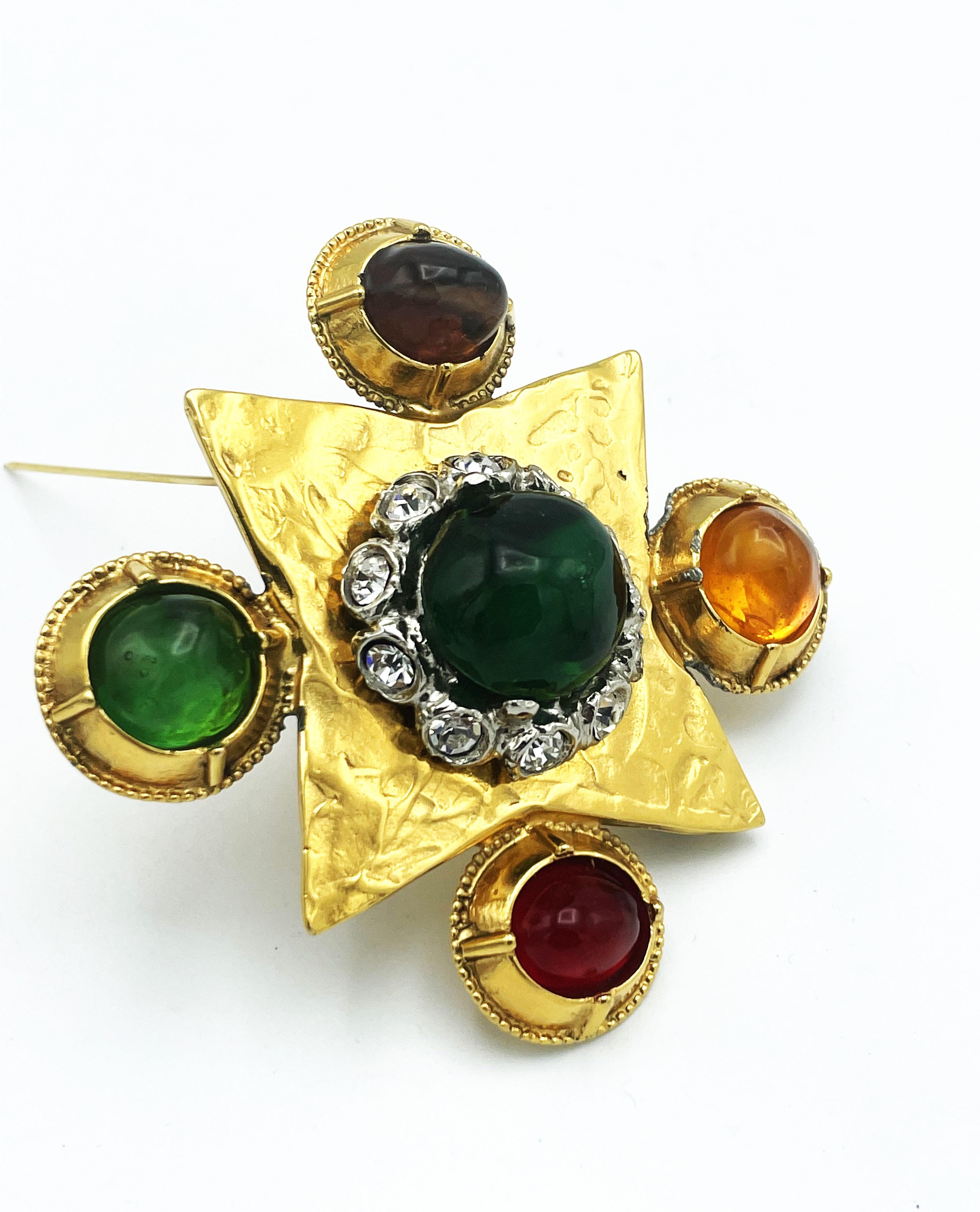 Yves Sant Laurent  rive gauch by Robert Goossens cross brooch in hammered gilt metal polychrome resin cabochons and rhinestones.
The green resin cabochon in the middle is surrounded by set clear rhinestones. At the corner 4 more collored resin