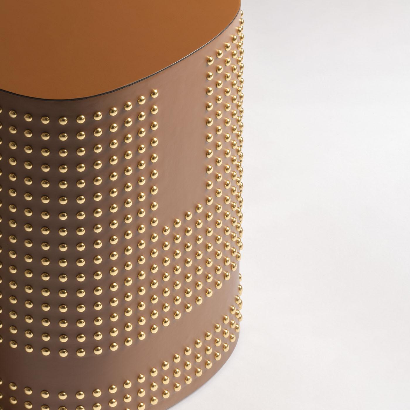 A seamless, organic blend of essential lines and ornate detailing, this spectacular stool is distinguished by golden tacks and a lavish leather cover paying tribute to the 1800s style. Effortlessly merging classic and modern, adorned with the