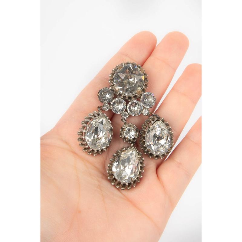 UNKNOWN - Articulated silvery metal brooch with rhinestones. Not signed jewellery from the 1930s.

Additional information:
Condition: Very good condition
Dimensions: Length: 7 cm
Period: 20th Century

Seller Reference: BR28