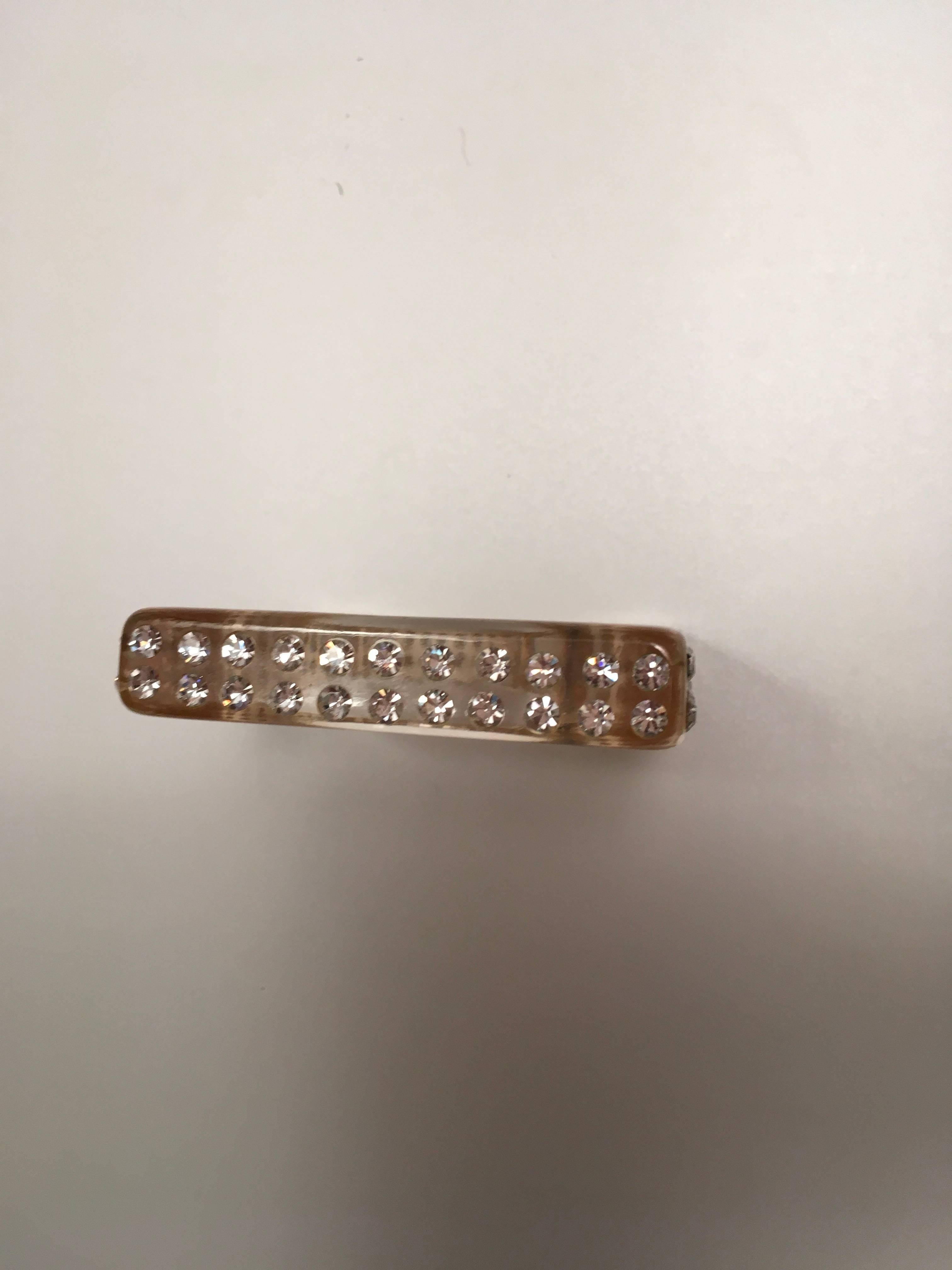 This is a magnificent Lucite and rhinestone bracelet from the 1950's. The outside is a square shape measuring  3 inches by 3 inches with 2 rows of rhinestones on each of the four sides.
the inside diameter is 2.5 inches. It is a rare example of a a