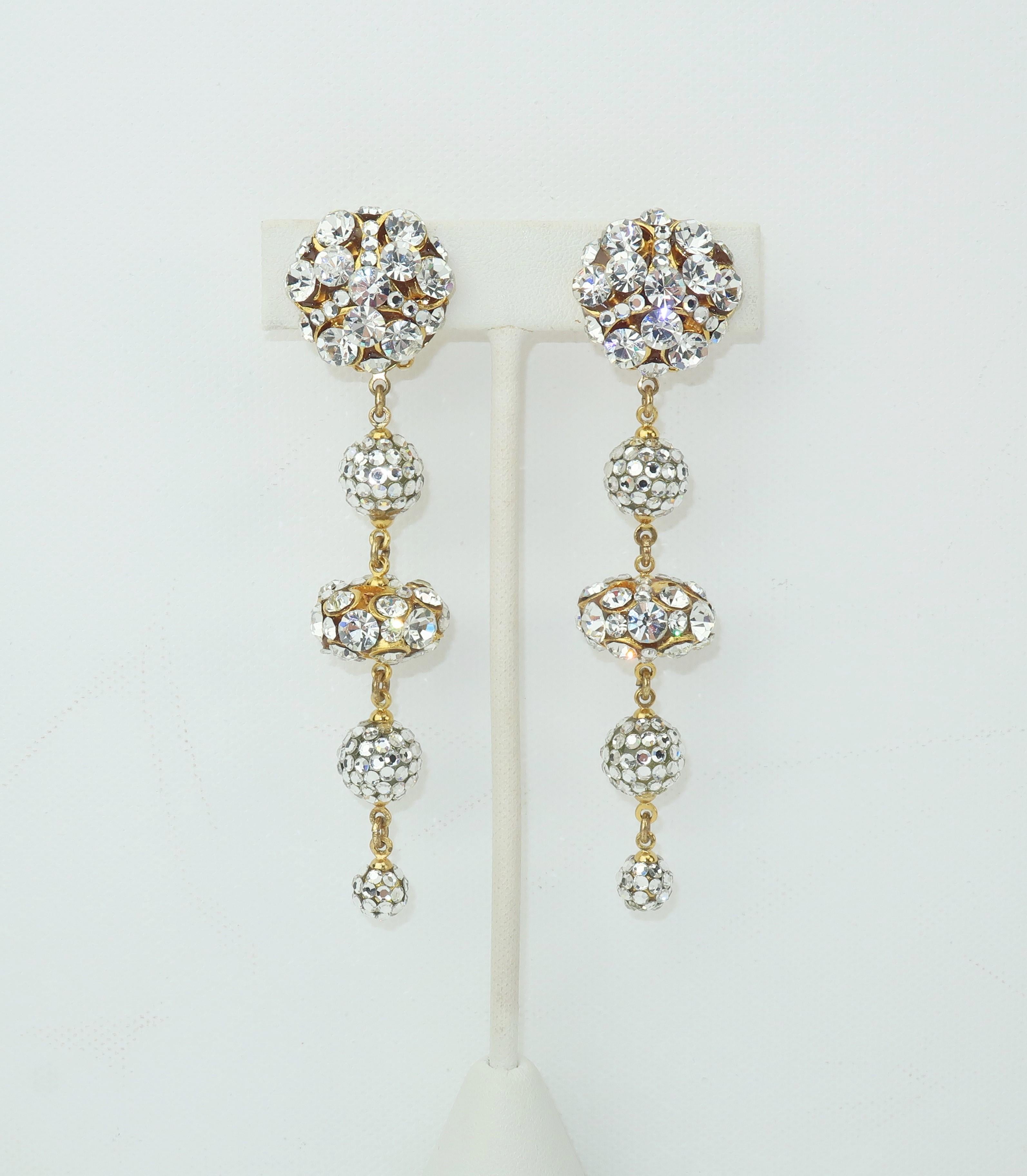 Dazzling and delightful!  These C.1980 clip on gold tone earrings sparkle with dangling orbs embellished by rhinestones and pave crystals.  Beautifully made and in very good condition with the hint of adhesive remnants from old earring pads to the