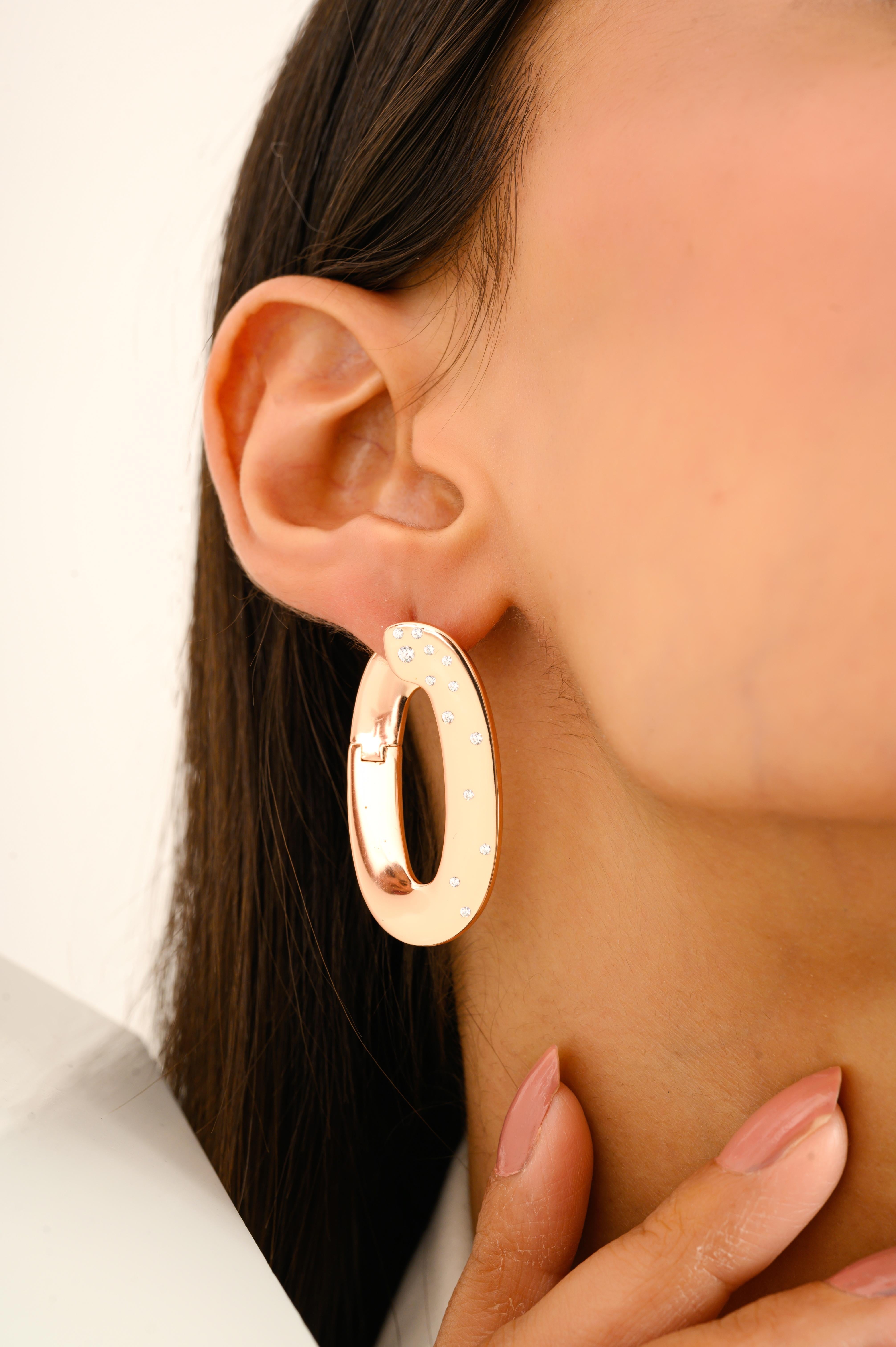 questi orecchini a cerchio ovali sono realizzati in pregiato argento sterling 925 e rifiniti in una calda tonalità oro rosa. La superficie satinata aggiunge una morbida lucentezza, mentre i delicati accenti di zirconia cubica sono sparsi ad arte