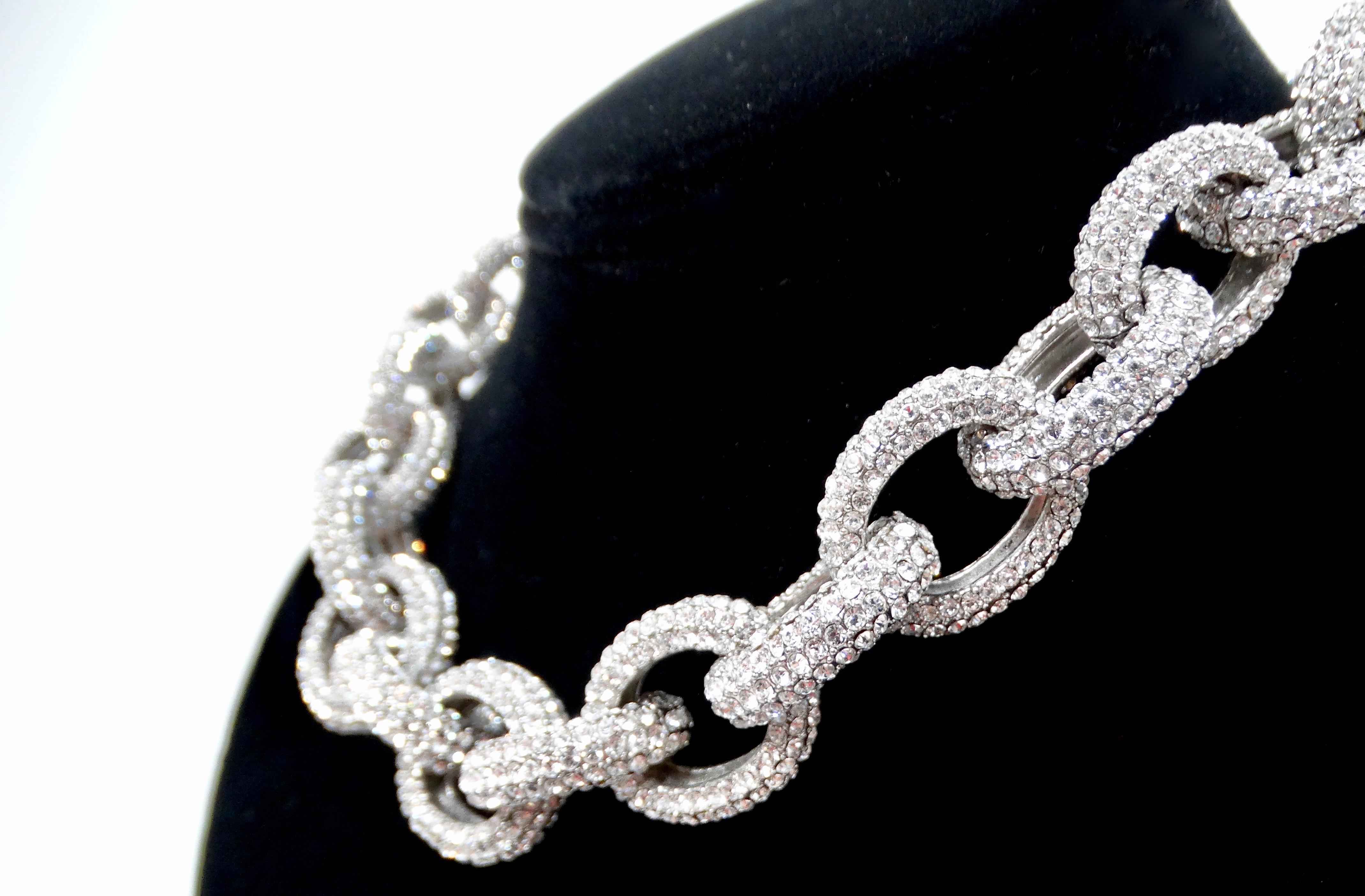 Eleva il tuo gioco di accessori con la collana girocollo con strass A. Silver-Tone Chunky Link Chain. Questo splendido pezzo è caratterizzato da un audace design a maglie grosse ornato da strass scintillanti che catturano la luce in modo