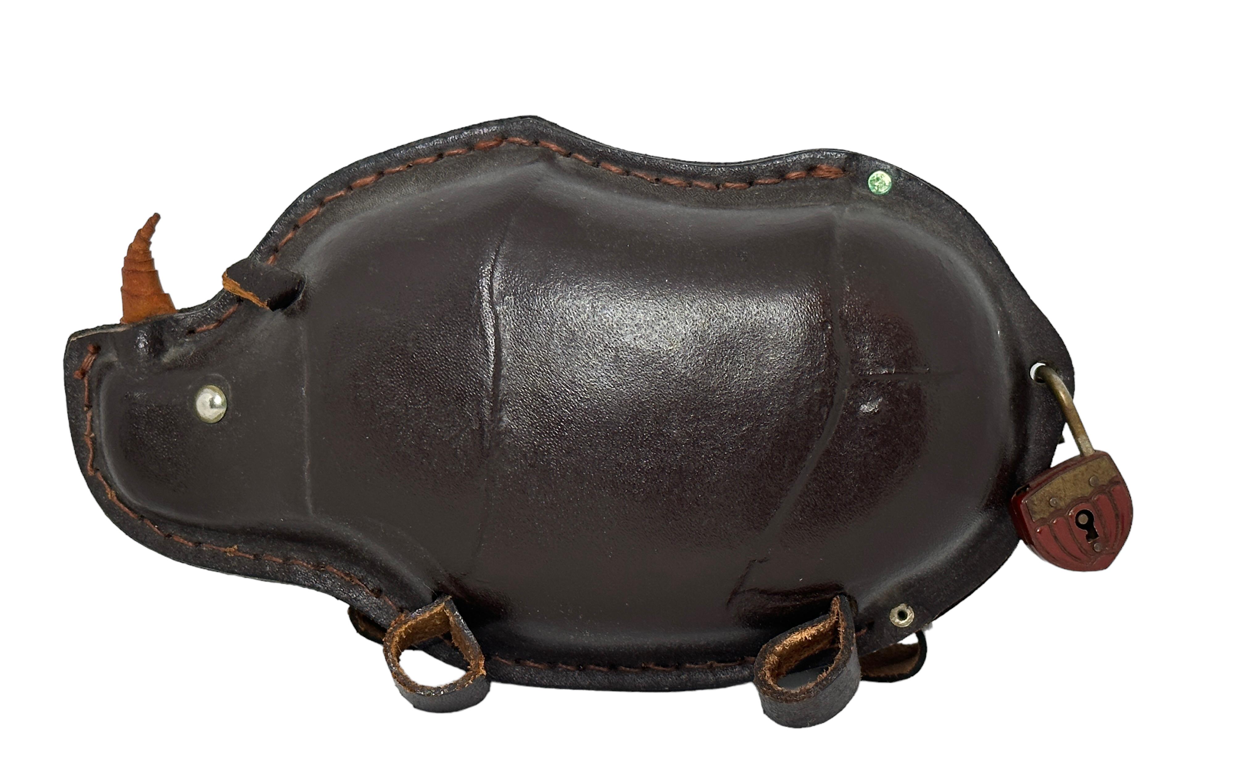 Wunderschöne, aus Leder gefertigte Spardose Rhino. Ein schöner Dekorationsartikel aus dunkelbraunem Leder mit einem kleinen Metallschloss. Es tut mir sehr leid, dass der alte Originalschlüssel nicht mehr vorhanden ist. Hergestellt in Europa in den