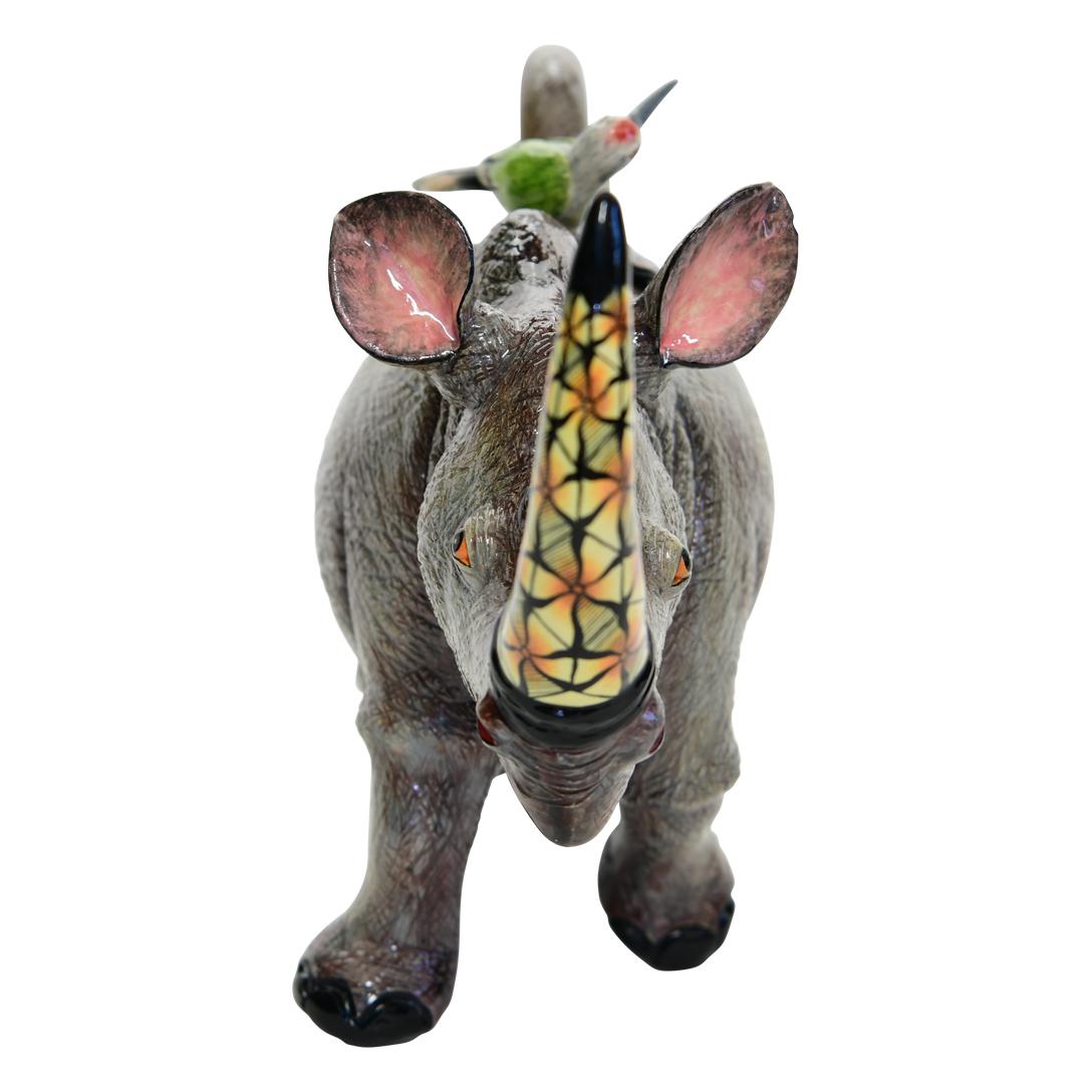 This Rhino Teapot was hand sculpted by the renowned artisan Sondelani Ntshalintshali and beautifully painted by Minenhle Nene both from South Africa. This exquisite ceramic creation stands 0 inches high, measuring 0 inches in length and 0 inches in