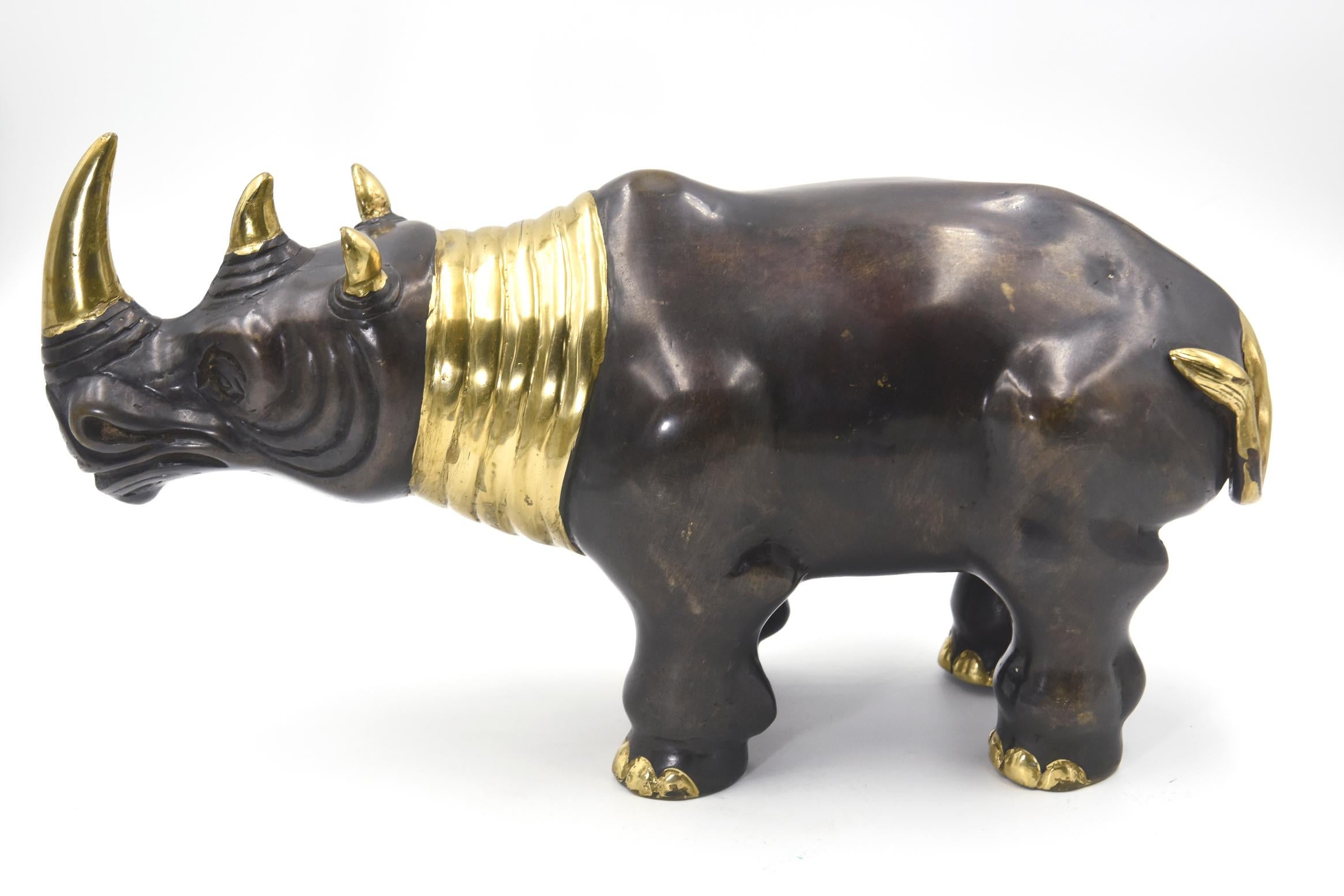 Finely made rhinoceros bronze sculpture featuring gilded accented on its neck, horns, ears, tail and toes. There is no mark on this piece.

 