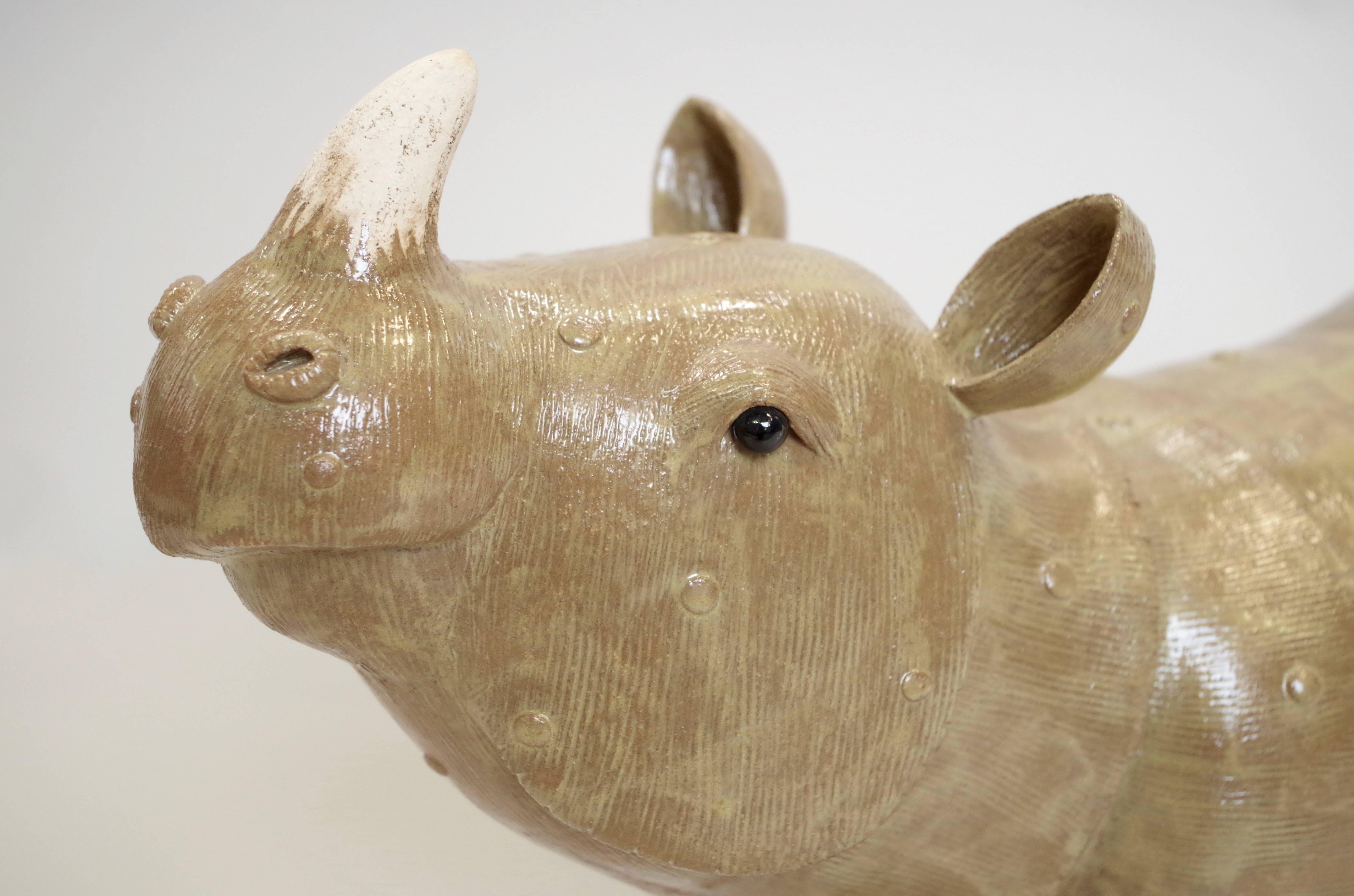 Rhinoceros sculpture in glazed stoneware. 
This sculpture is made by the French contemporaneous artist Valérie Couret. 
She learned with Jacques Peiffer, Meilleur Ouvrier de France, in the Saint-Jean l'Aigle de Longwy Manufactory, how to apprehend