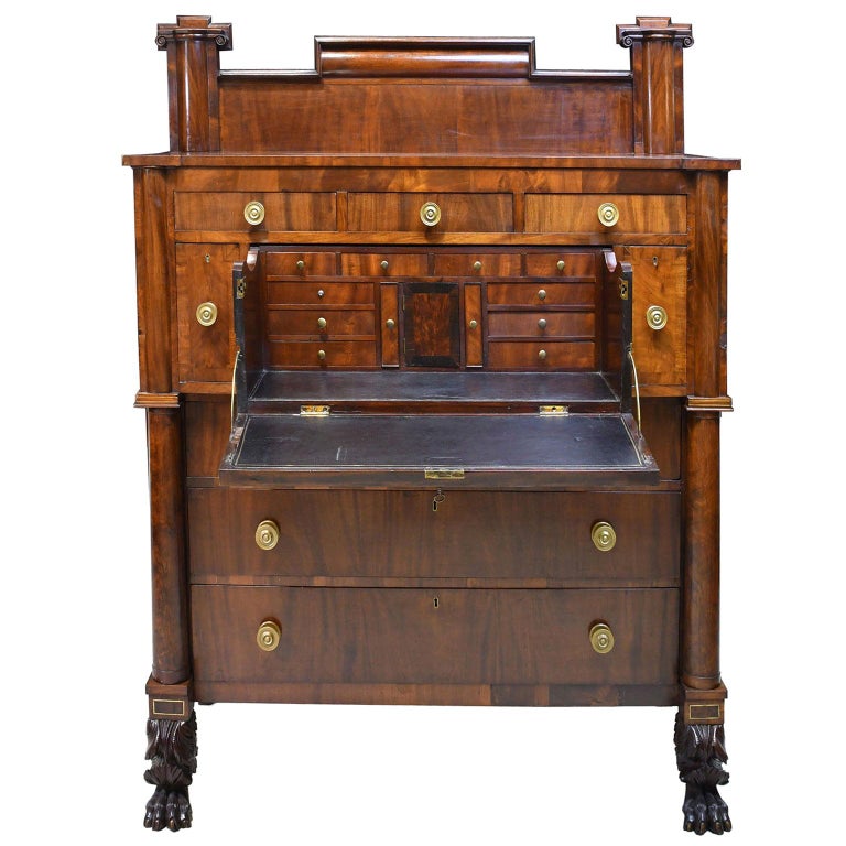 A beautiful example of an early American Empire chest with full-column front and stand-up butlers desk. Provides ample storage as a chest of drawers, and doubles as a secretary with additional small drawers in the interior. Rests on well-articulated