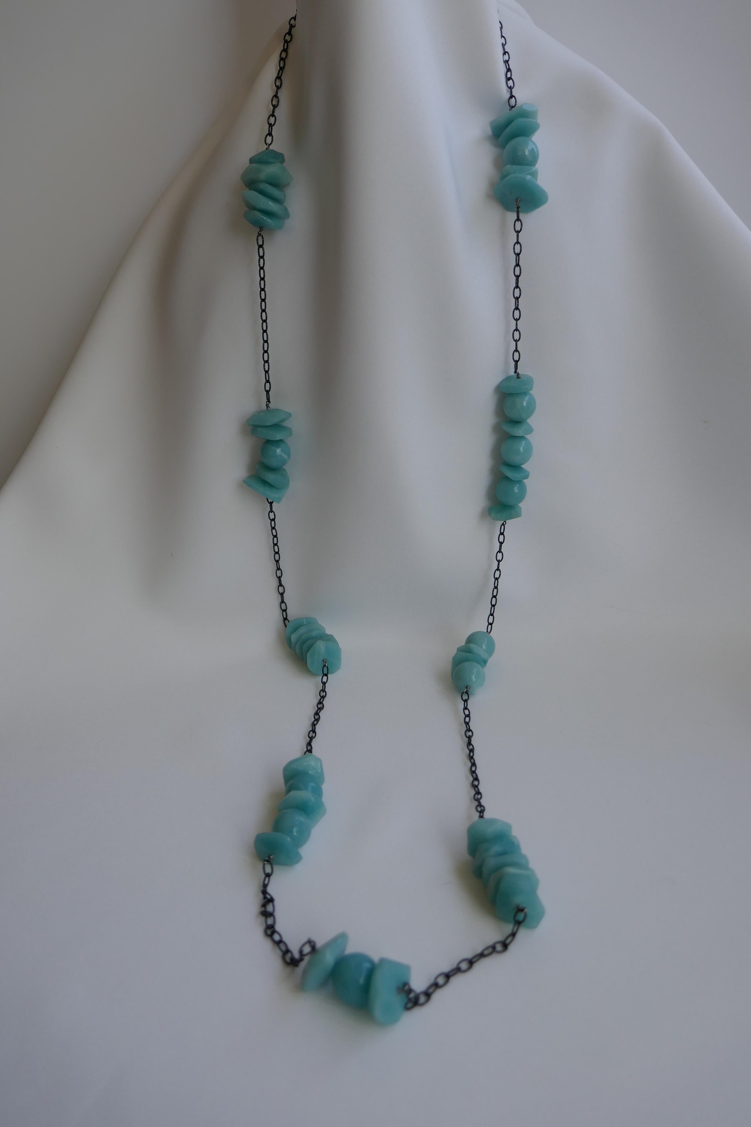 The chain is 925 rhodium plated oxidized silver with two shapes of amazonite gemstones 14mm. The necklace can be worn long or doubled and layered with other pieces. The necklace was designed by Lucy de la Vega/de la Vega designs and made in the U.S.