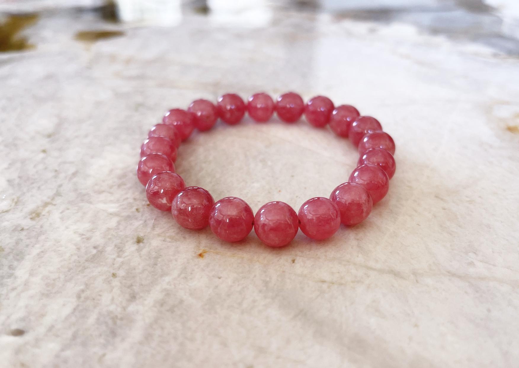 This is a truly spectacular natural rhodochrosite stretch stacking bracelet comprised of top quality 10mm round natural rhodochrosite beads. This bracelet was handcrafted in the USA by Rocat Designs and is approximately 7 inches (17.8 cm) long. The
