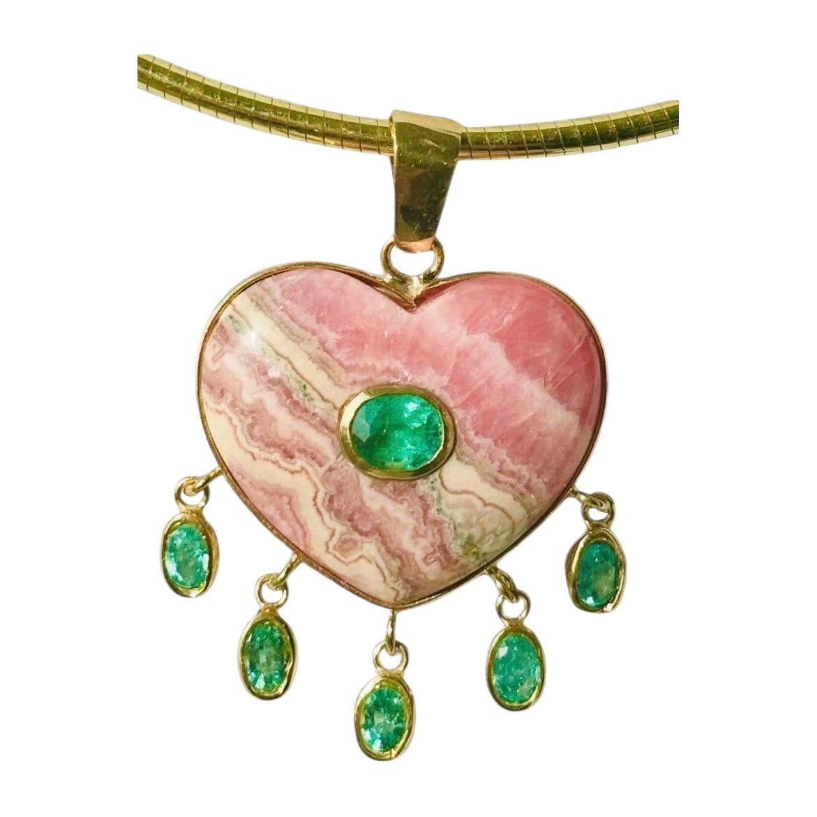 Grand pendentif coeur en rhodochrosite avec émeraudes

Rhodochrosite, émeraudes et or 14k

Coeur en rhodochrosite sculptée (30 mm de diamètre) avec au centre une émeraude ovale sertie d'or et cinq émeraudes ovales pendantes. 

La rhodochrosite est