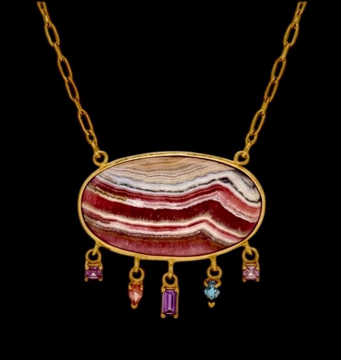 Rhodochrosite Necklace with Spinel

Rhodochrosite, Spinel & 14k Gold 

Center oval Rhodochrosite (1.5” width) in stunning rich mauves and grey color-way, bezeled in 14k gold with five dangling sparkly spinels on a solid gold chain.

This necklace is