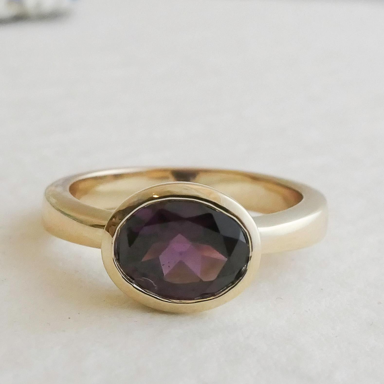 Ein ovaler Rhodolith-Granat von 8,5 x 6,5 mm ist in 14-karätigem Gelbgold gefasst.  
Ringgröße ist 7
