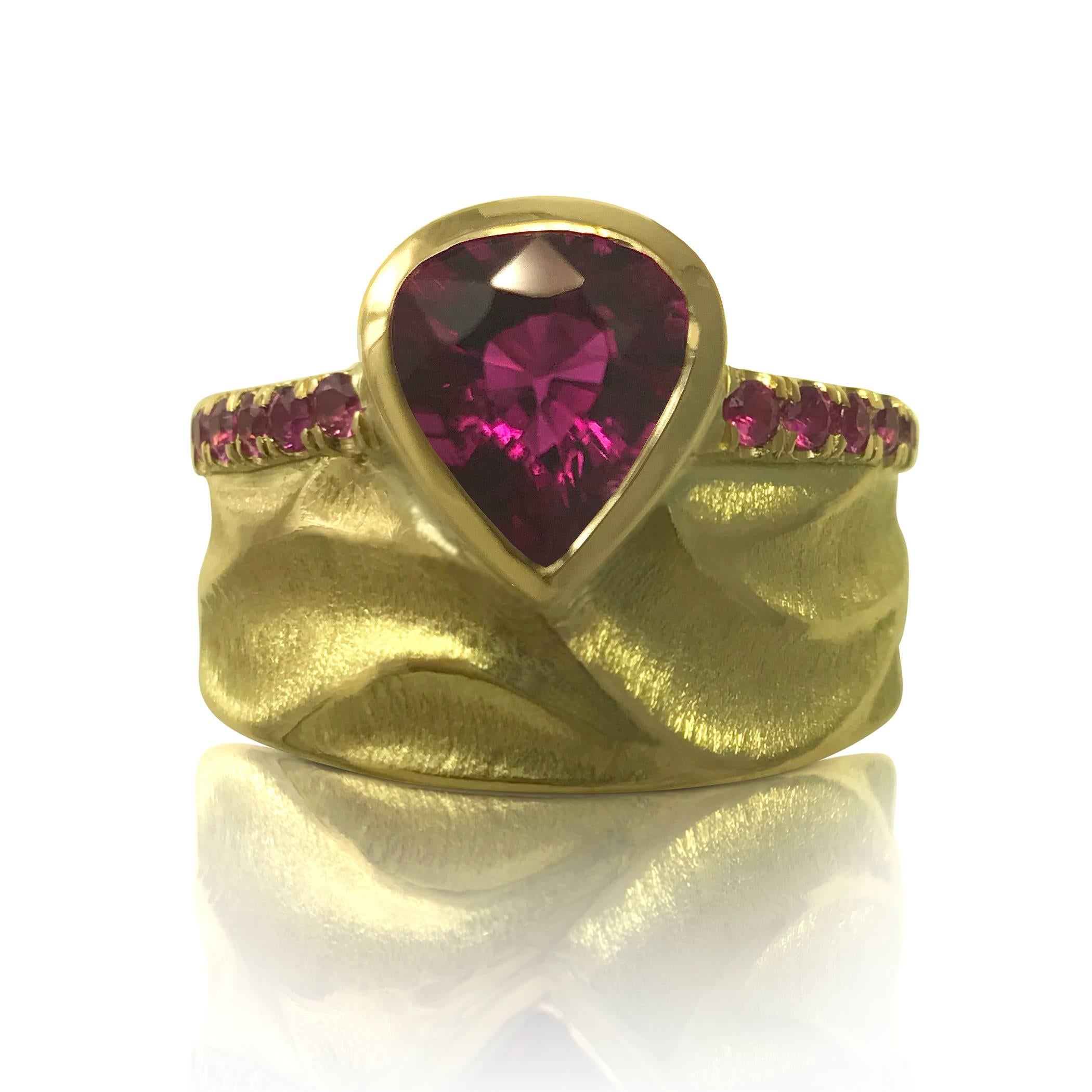 The Royal Crown Ring, which features my signature “dune” texture, is 15mm wide and is made from 18k yellow gold. A spectacular 1.2ct rhodolite garnet is the focal point. Around the edges are 0.27ct of pink sapphires that gradually become lighter as