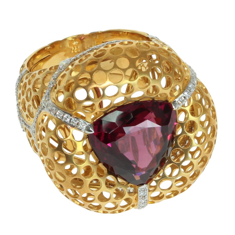 Rhodolite Garnet 8.22 Carat, Diamonds 18 Karat Yellow Gold Ring
Have you ever seen swallow nests? It's many small holes in the cliffs. Our designers decided to embody this idea in this spectacular Ring. 
Inside Matte 18K Yellow Gold are many slots