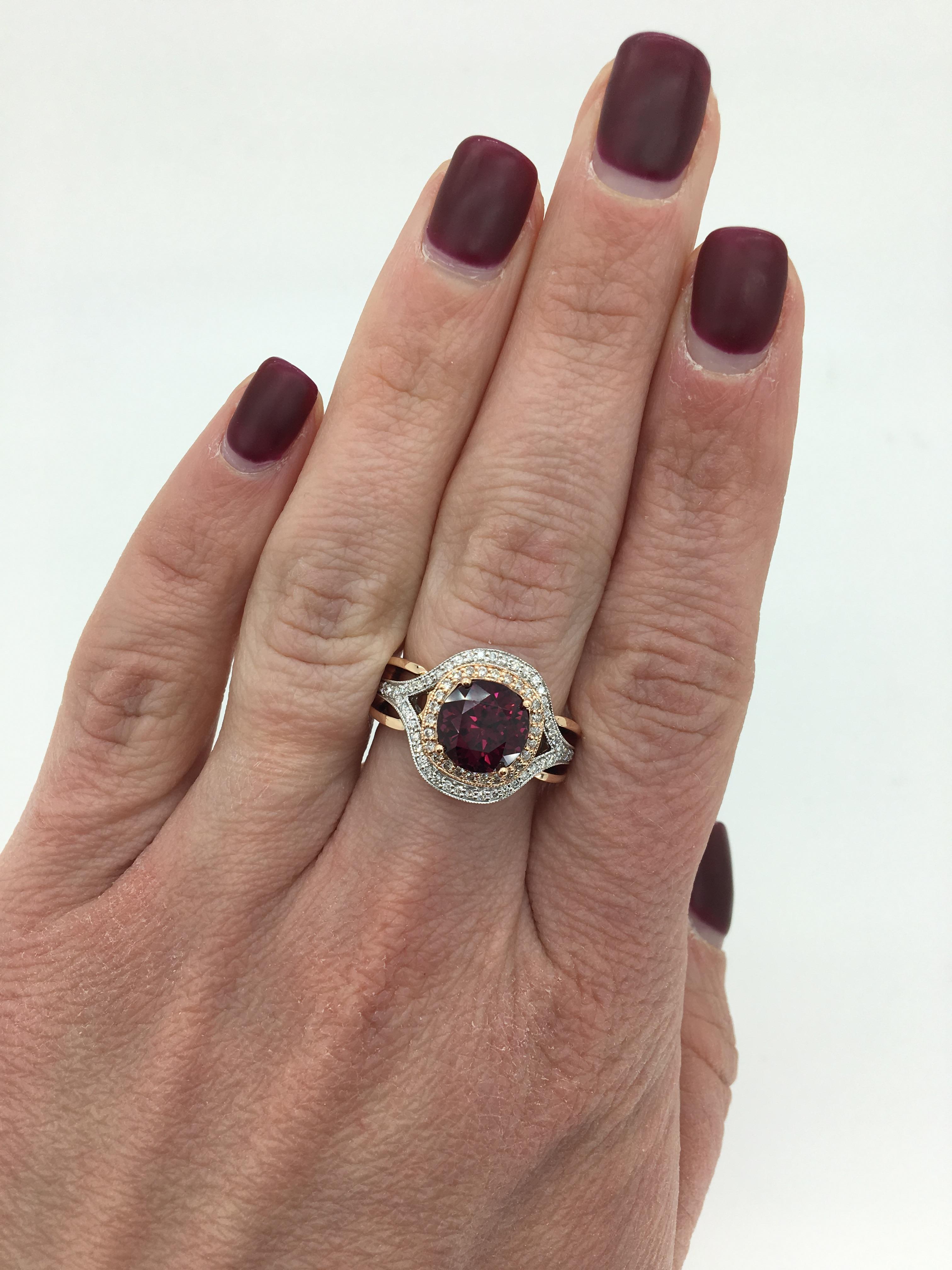 14K two tone rose and white gold cocktail ring featuring a stunning 3.29CT round cut Rhodolite Garnet surrounded by an elegant halo of round brilliant cut diamonds.

Gemstone: Round Cut Rhodolite Garnet
Gemstone Size: 3.29CT
Accent Diamonds: Round