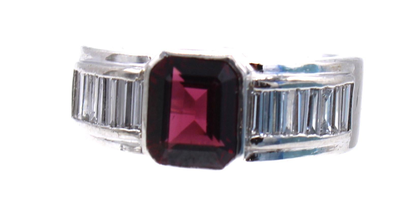 Wonderfully hand-crafted in platinum this geometrically designed ring features rectangular step-cut Rhodolite Garnet weighing 1.63 carats, in a centrally raised bezel. On either side of the gemstone 6 perfectly matched baguette cut diamonds,