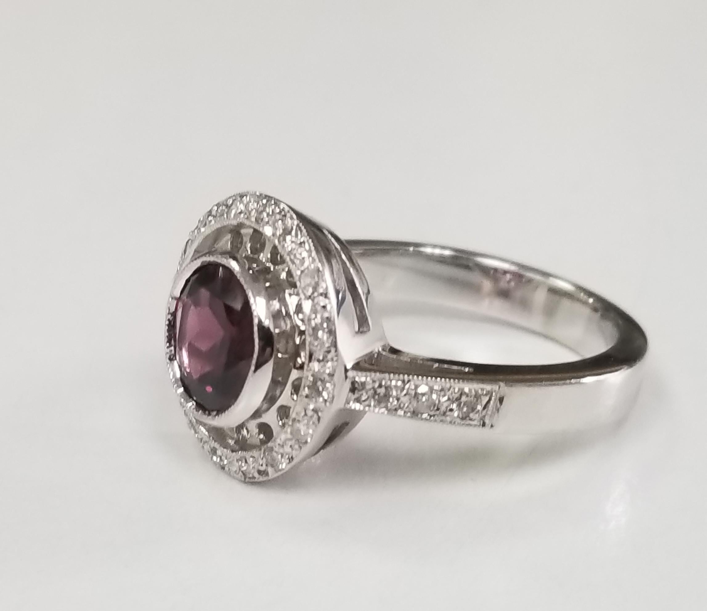 14k white gold garnet and diamond ring, containing 1 rhodolite garnet of gem quality weighing 1.29cts. and 24 round full cut diamonds of very fine quality weighing .30pts.  This ring is a size 6 but we will size to fit for free.