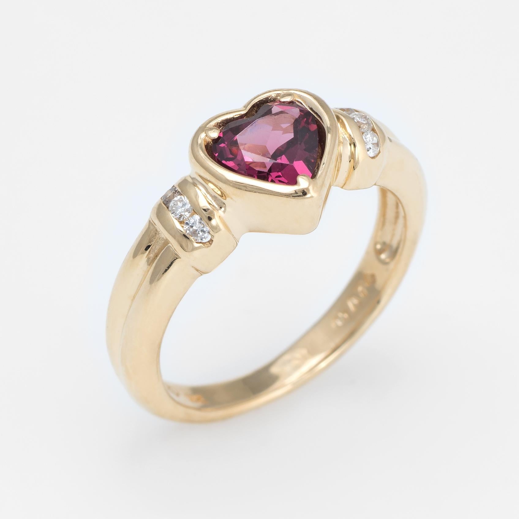 Stylish estate rhodolite garnet & diamond heart ring crafted in 14 karat yellow gold. 

Heart cut rhodolite garnet is estimated at 1.25 carats, accented with an estimated 0.06 carats of diamonds (estimated at H-I color and SI2-I1 clarity). The
