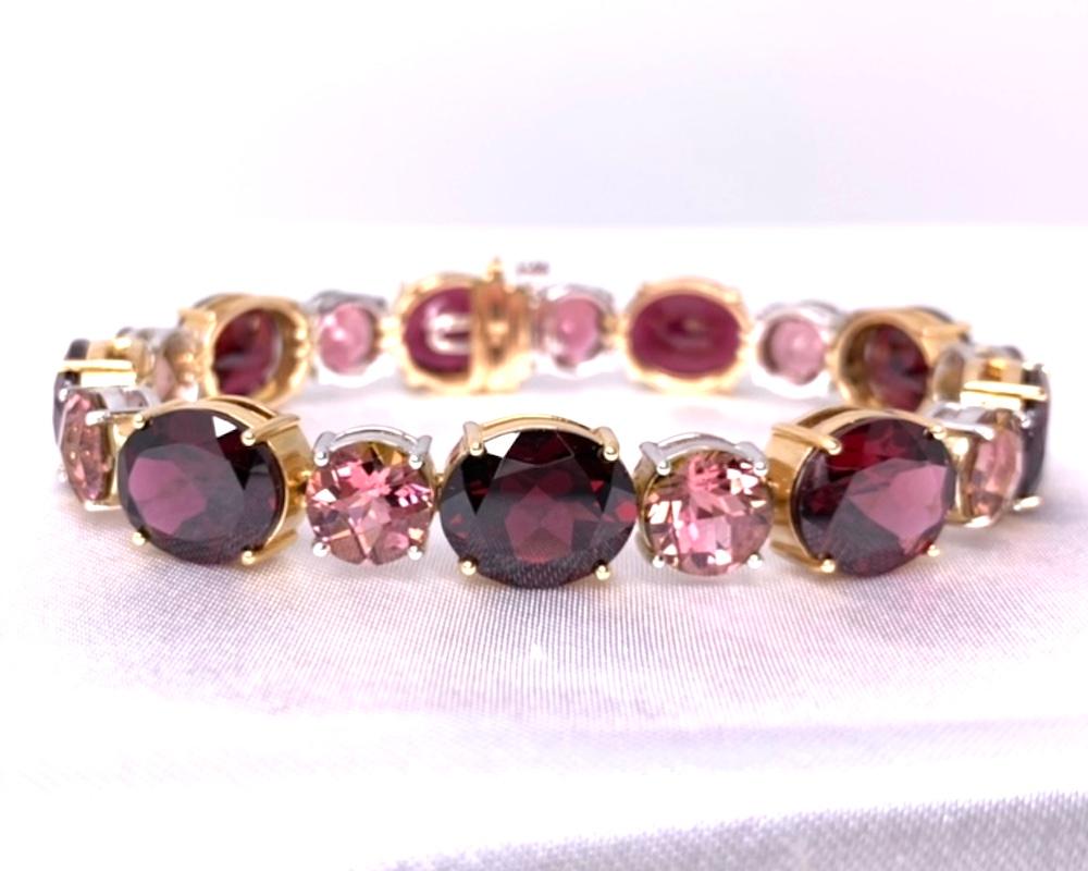 This handmade 18k white and rose gold tennis bracelet features luscious rhodolite garnets and bright pink tourmalines weighing just over 70 carats total! 18k rose gold was chosen to accentuate the vivid rhodolite garnets (aptly named by the Greek