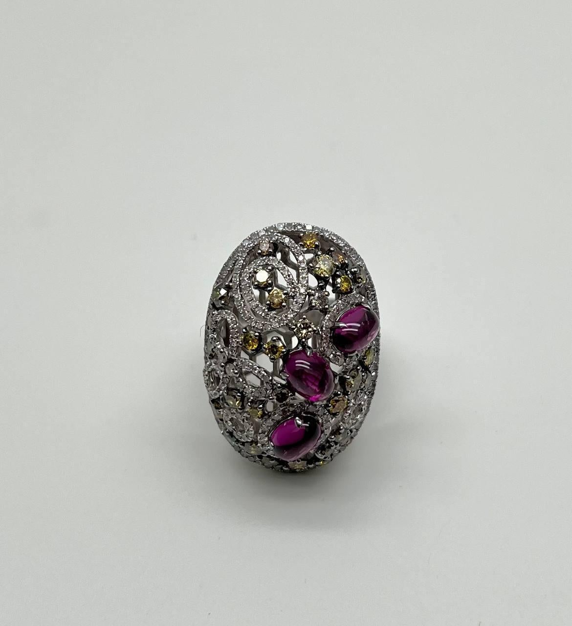This captivating piece features a dynamic design with a lattice-like structure, adorned with vibrant gemstones. The surface is embellished with sparkling yellow and green stones, creating a dazzling effect.

Three prominent pink cabochon stones are