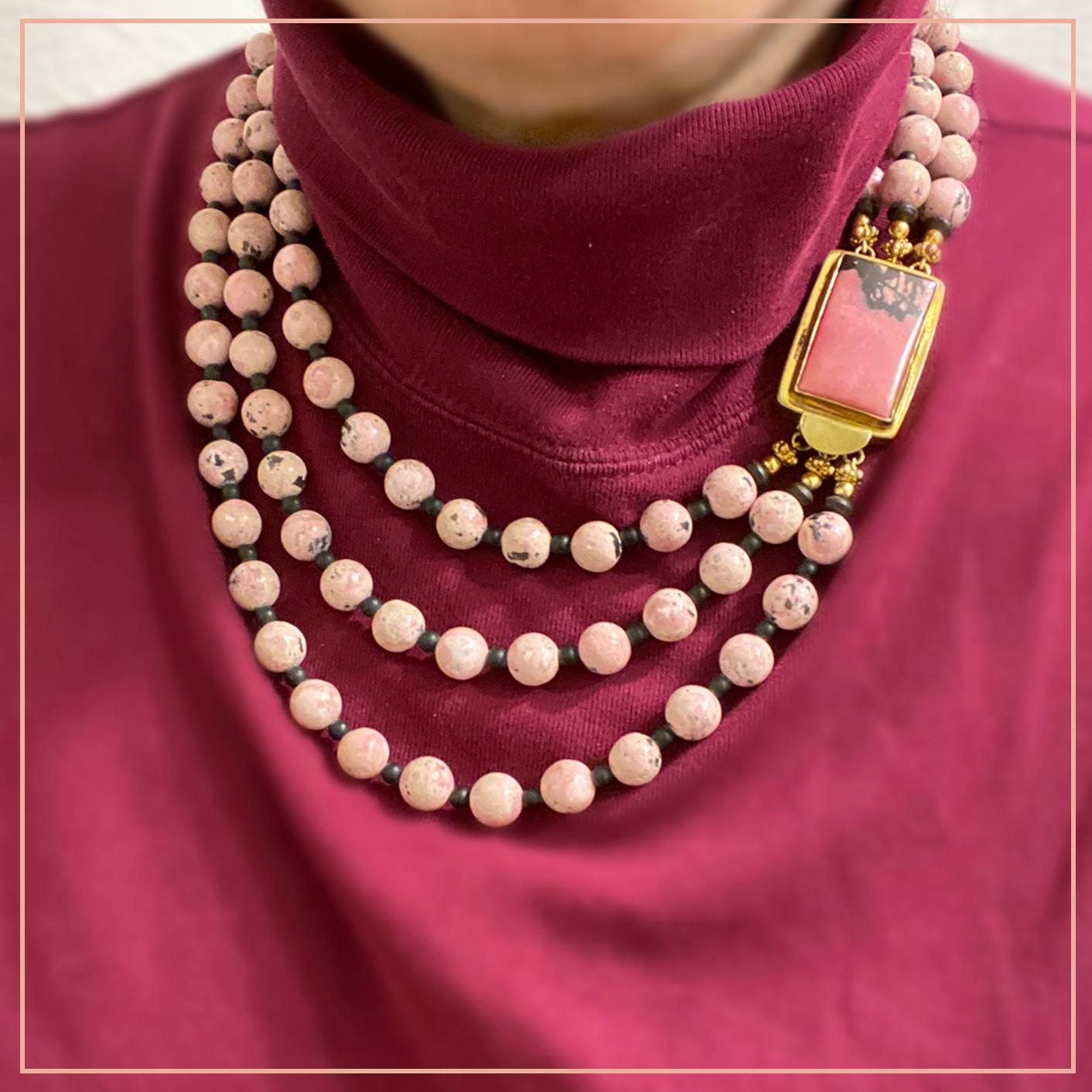This triple strand necklace was created by Nouveau Boutique with 10 mm matt rhodonite beads and smaller jet beads as spacers. It is hi-lighted with a large rectangle (1.5