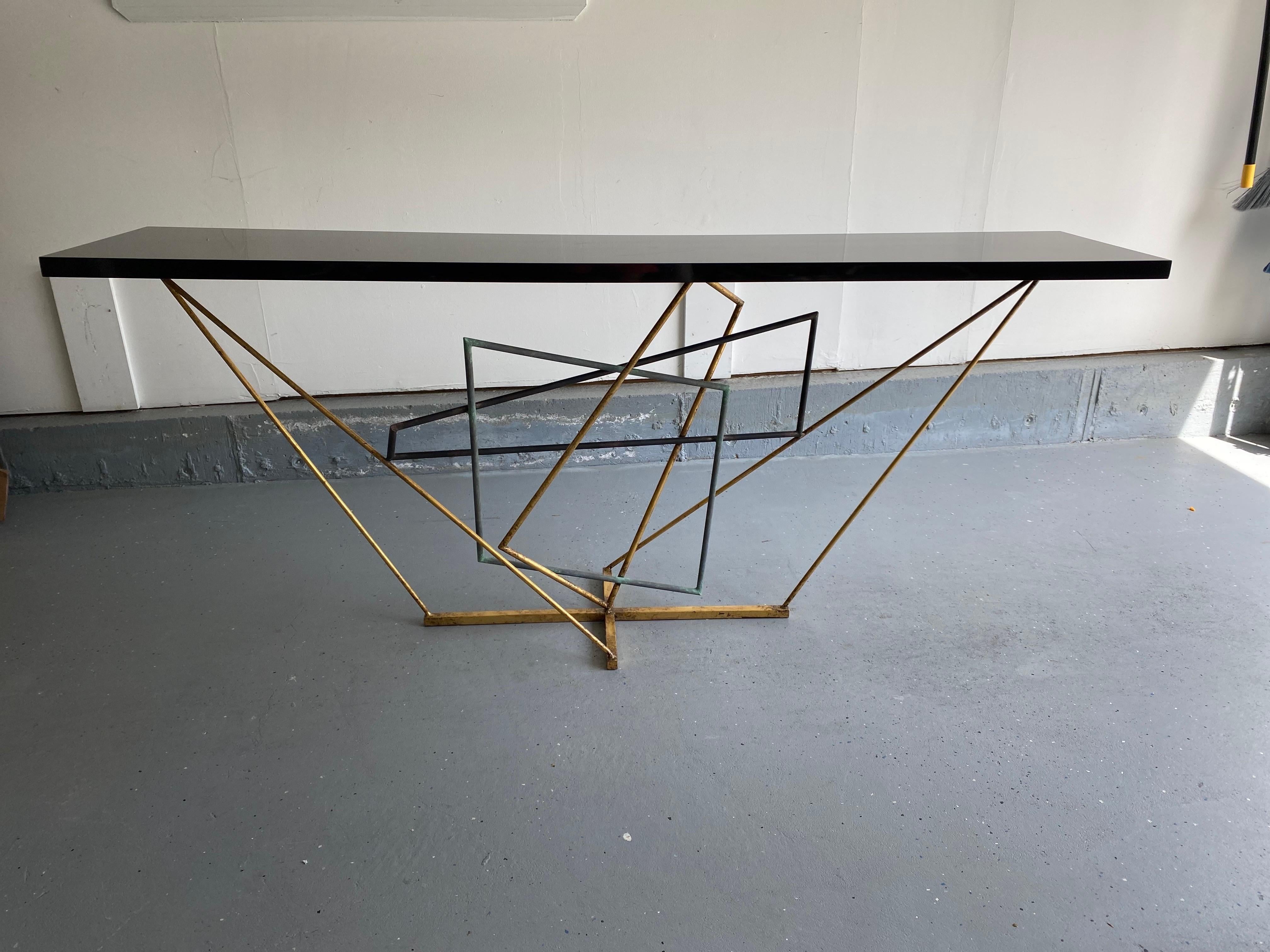  Rhomboid Console Table was designed by Gareth Devonald Smith for Porta Romana
Forged Steel in three finishes: verdigris, scratched gold, and fired copper finish with a black lacquered wood top. Table requires wall fixing. Anchor brackets on one