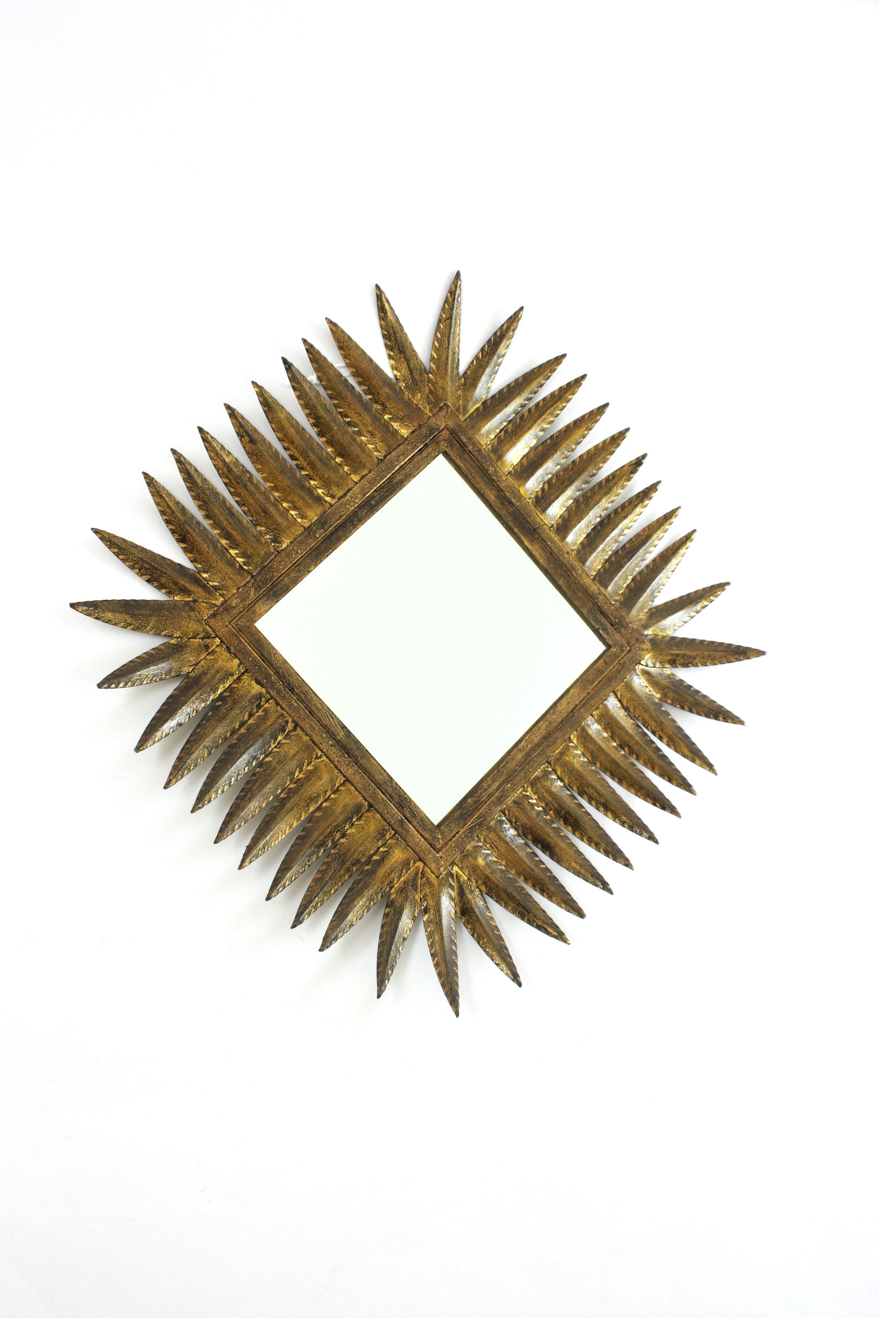 Miroir en fer doré martelé à la main en forme de losange. Espagne, années 1950. 
Il peut être placé dans deux positions. 
Fabriqué par Ferro Art. 
Ce miroir en forme de soleil sera un bel ajout à une salle d'eau ou à toute autre pièce. Il peut être