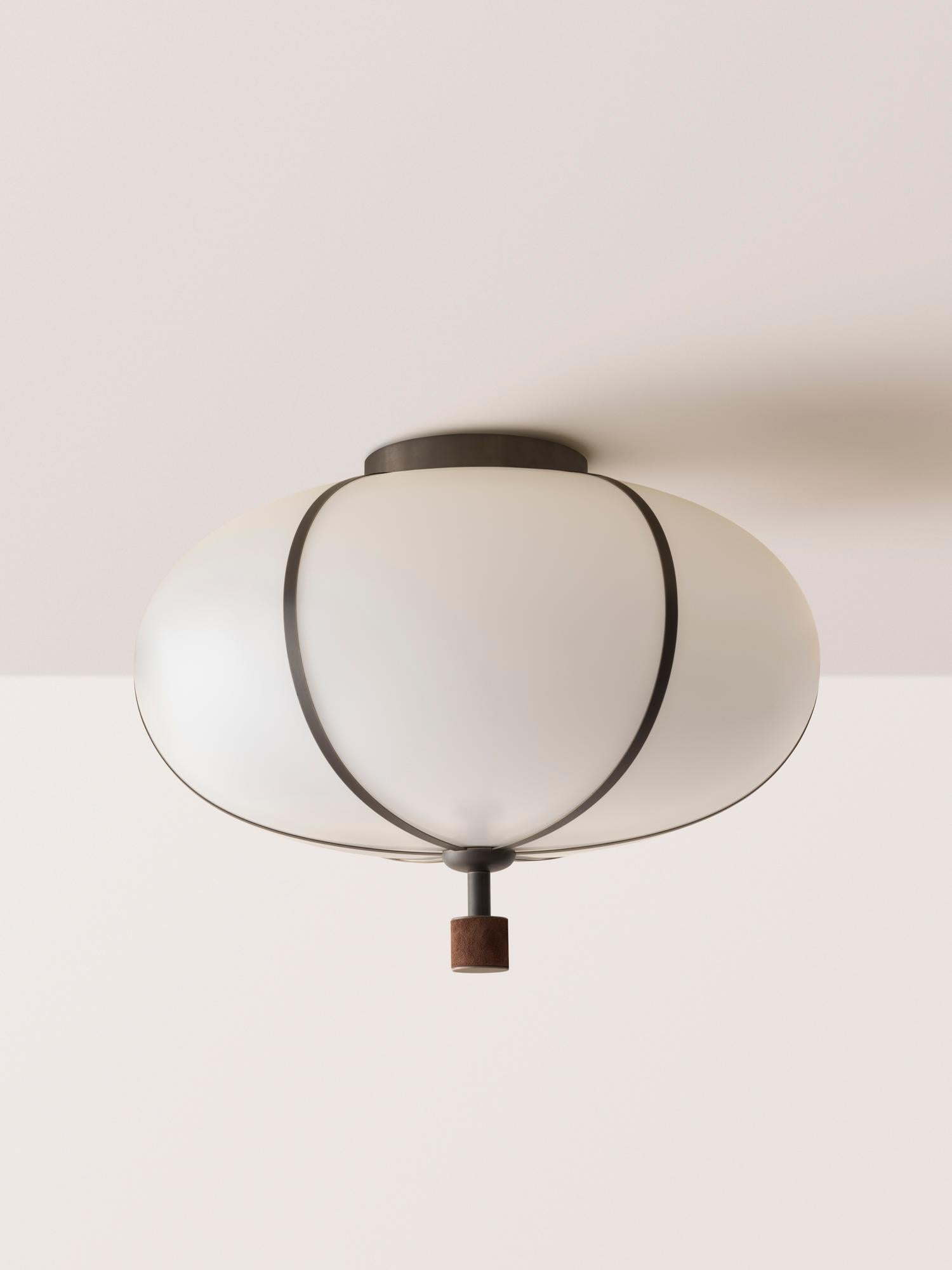 The Rib Flush Mount - Large Ellipse is blown in Italy and delicately framed by thin brass ribs. A cylindrical brass finial, with optional hand-wrapped leather or suede, elongates the fixture and adds a finishing touch of refinement.

This listing is