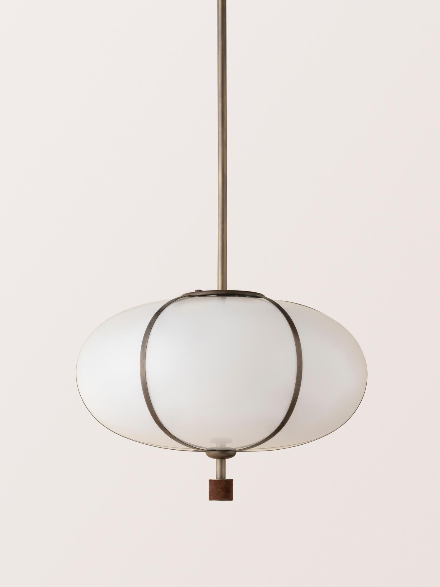 The Rib Pendant - Large Ellipse is blown in Italy and delicately framed by thin brass ribs. A cylindrical brass finial, with optional hand-wrapped leather or suede, elongates the fixture and adds a finishing touch of refinement.

This listing is