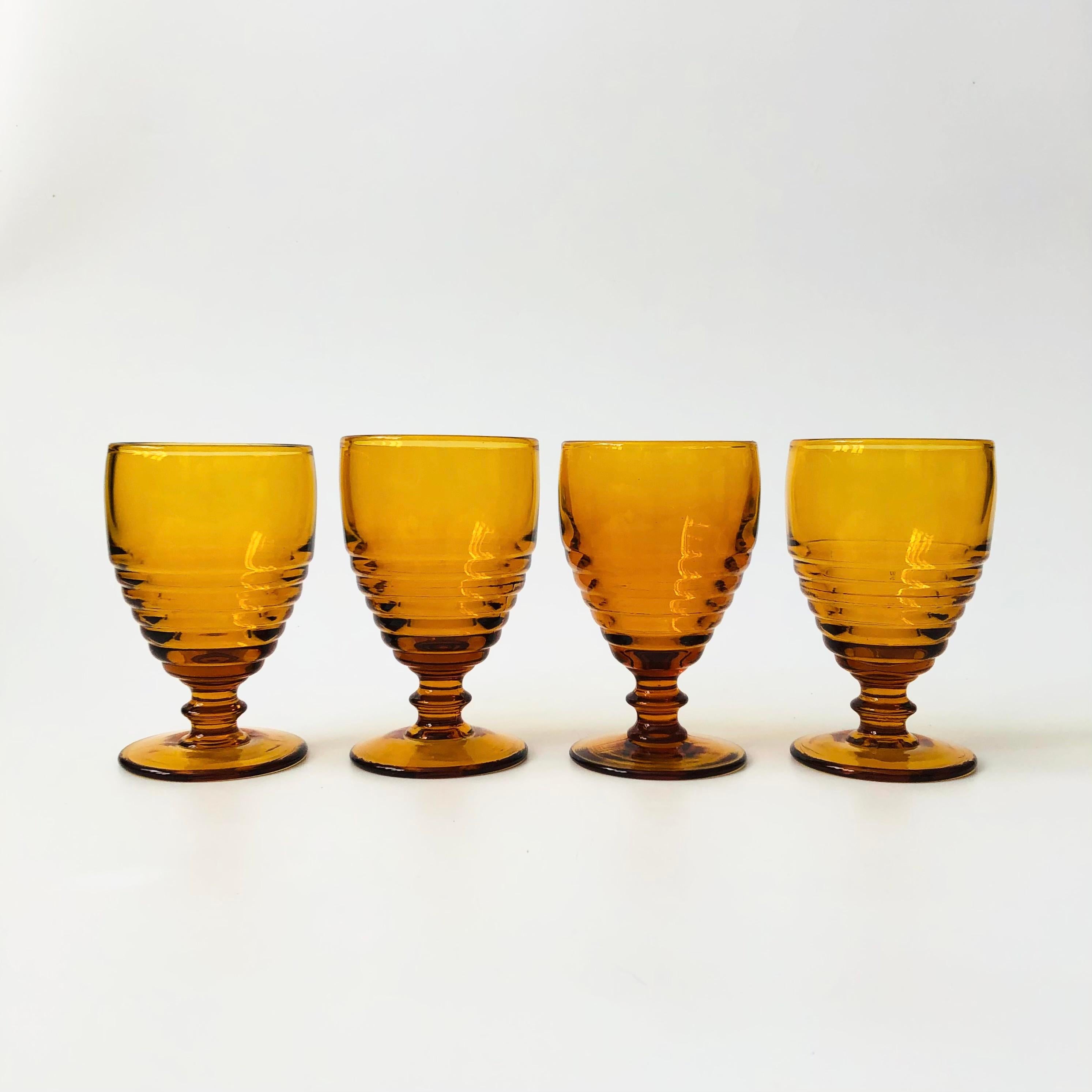 Un ensemble de 4 gobelets à vin en verre à dépression vintage. Forme nervurée unique d'une belle couleur ambrée. Fabriqué dans la ligne 