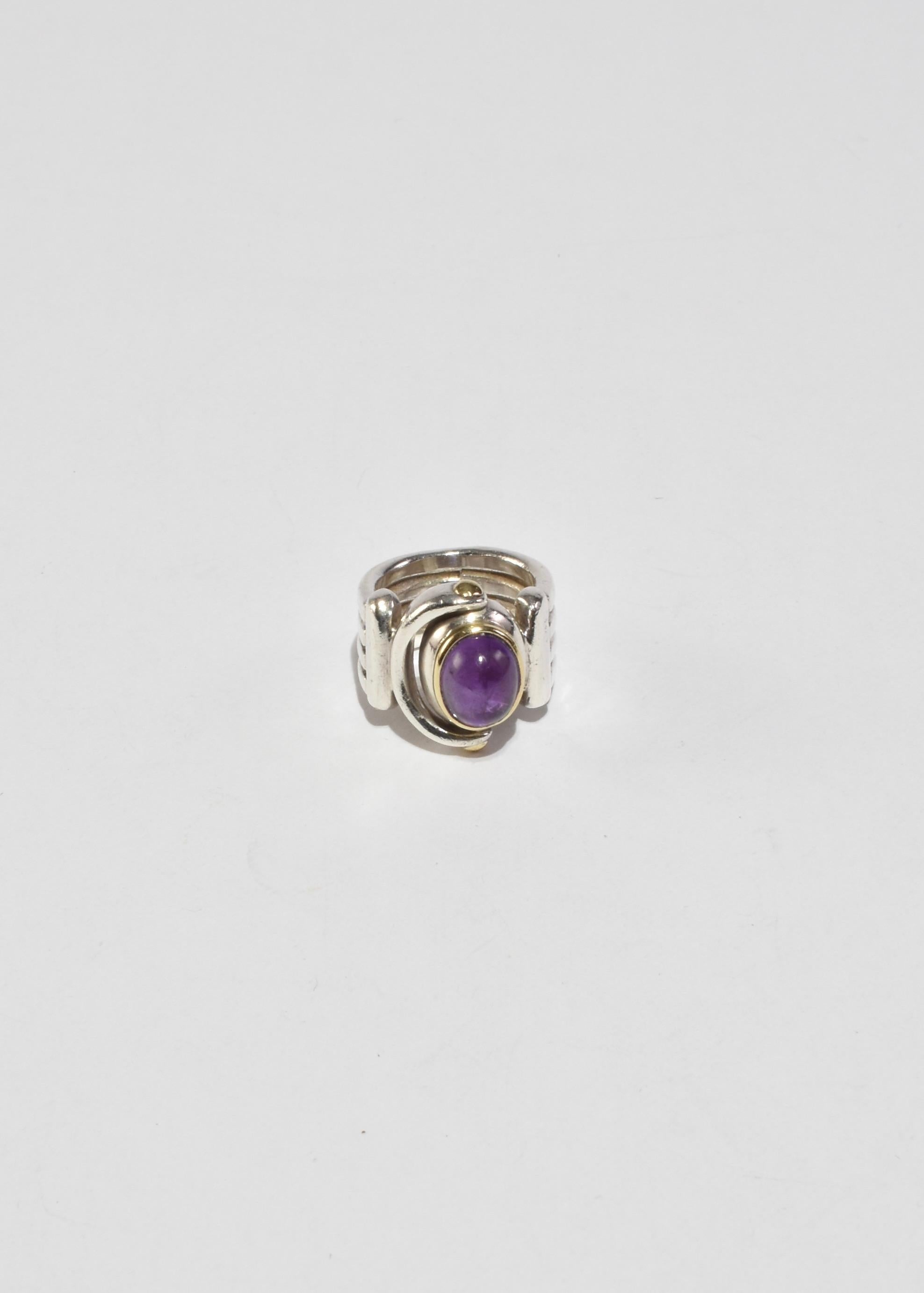 Rare, vintage sterling ribbed band ring with 14k gold detail and an oval amethyst cabochon.

Material: Sterling silver, 14k gold, amethyst.