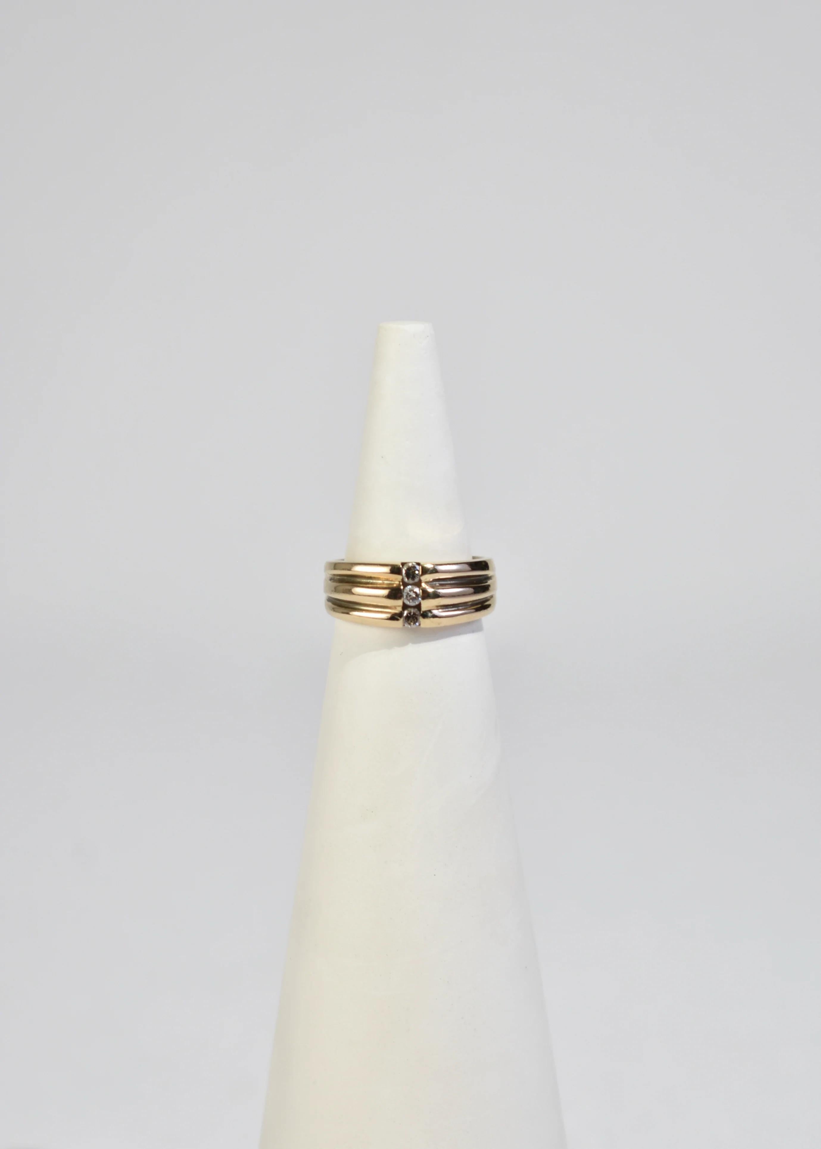 Stunning vintage gold ring with ribbed detail and three diamonds. Stamped 14k.

Material: 14k gold, diamond.

Size: 7.5
