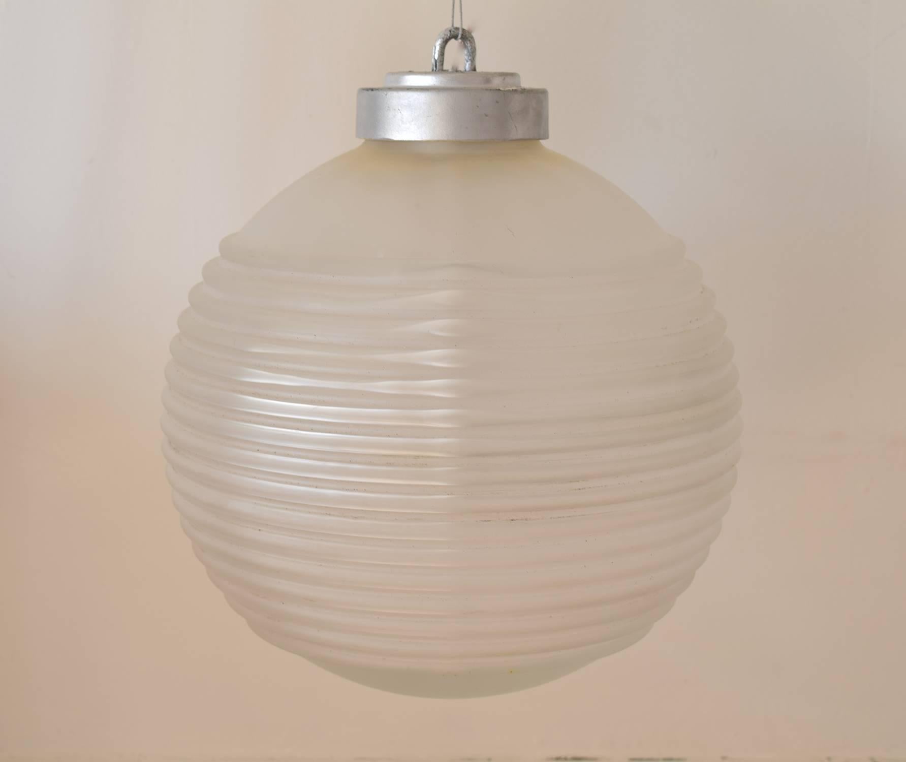 Stylish hanging light fitting.

Made of ribbed opaque glass with a silver colored Bakelite fitting at the top.

Both the glass and the fitting are threaded.

A very simple operation to split the two parts.

Free shipping.