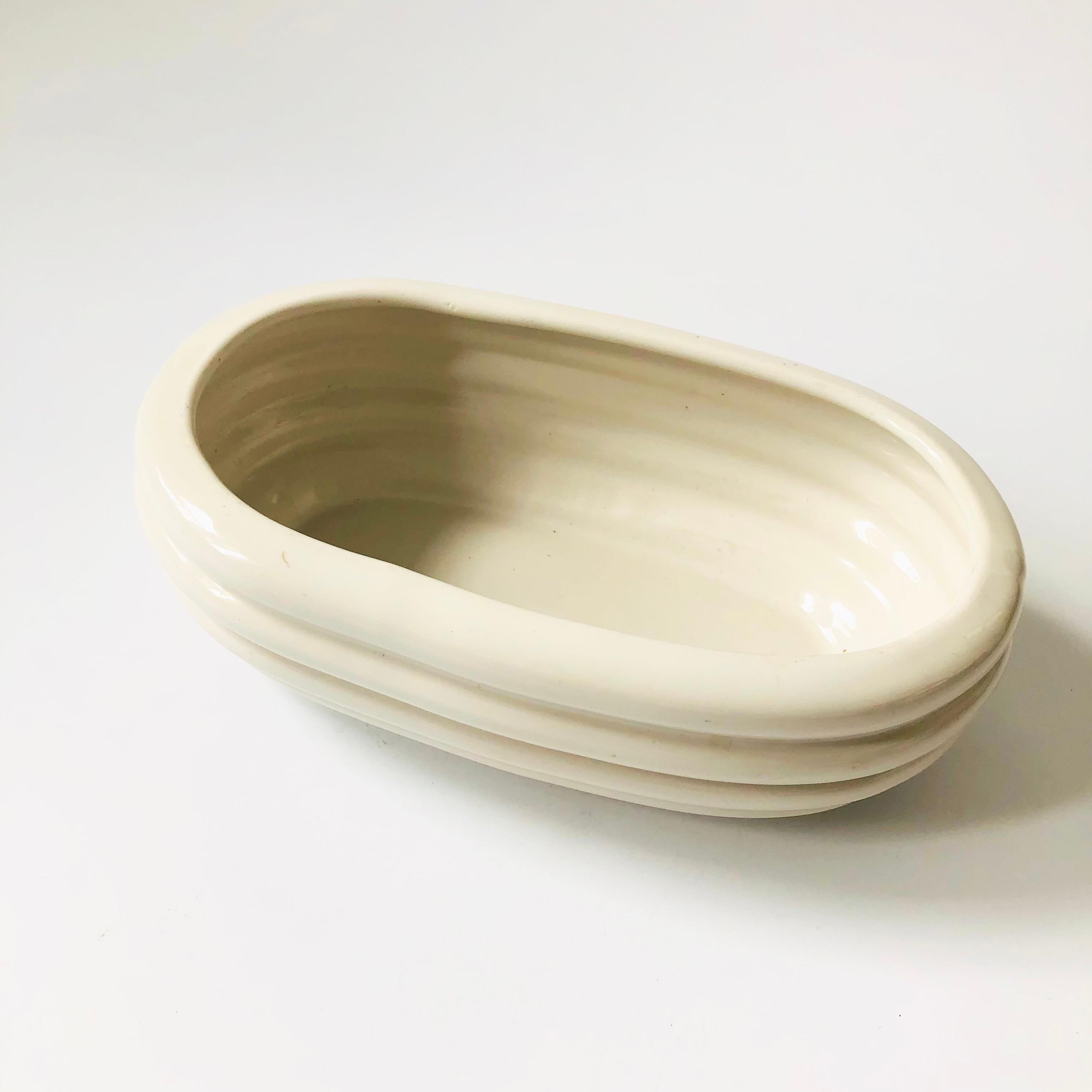 A vintage oval ceramic planter by Alamo, USA. Unique ribbed shape and finished in a glossy white glaze. Marked on the base by the manufacturer.

