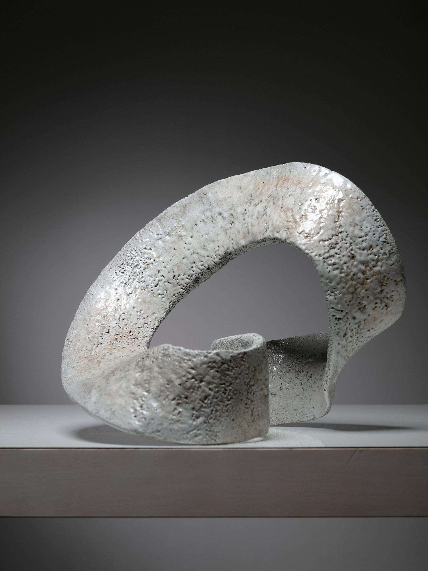 Ceramic sculpture composed by a revolving continuum stripe. 
