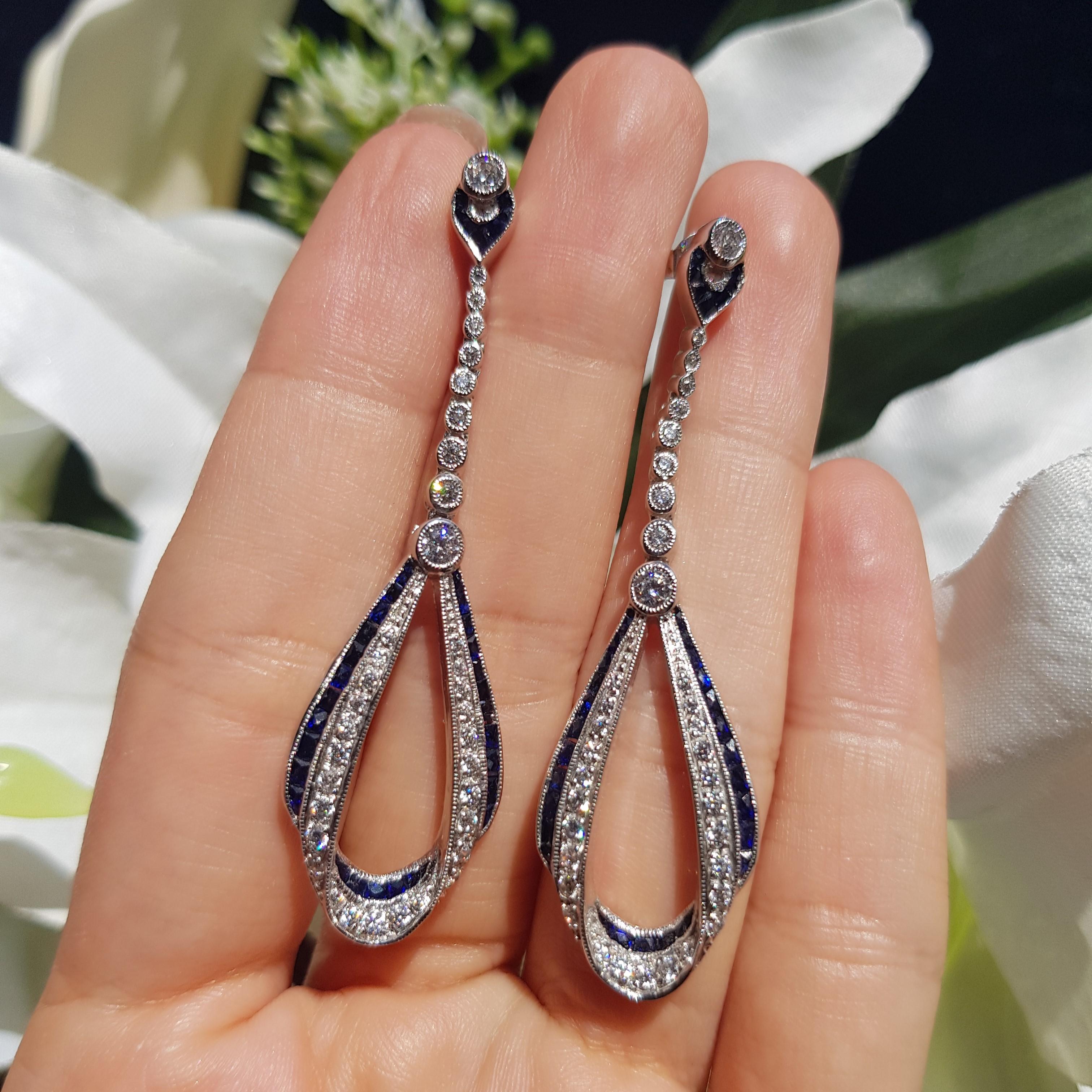 These Art Deco style drop earrings are absolutely stunning, extraordinary. Over 4 carats of vivid and exceptional blue sapphires border the edge of earrings. And 1.42 carats of fine diamonds. 
Artful and precise work in the 18k white gold combine