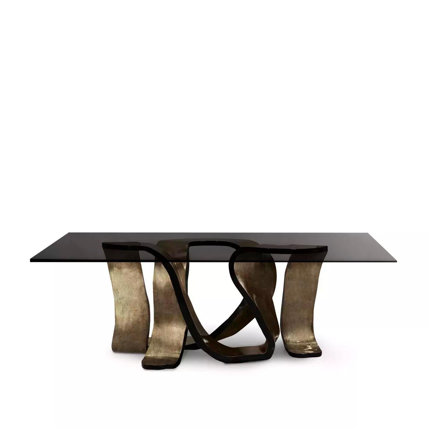 Laissez-vous emporter par le design rythmé de la table de salle à manger Ribbon. Les torsions provocantes de la base sont délicatement ornées de feuilles métalliques étincelantes, imitant l'éclat d'un ruban de cheveux de jeune fille. La base ludique