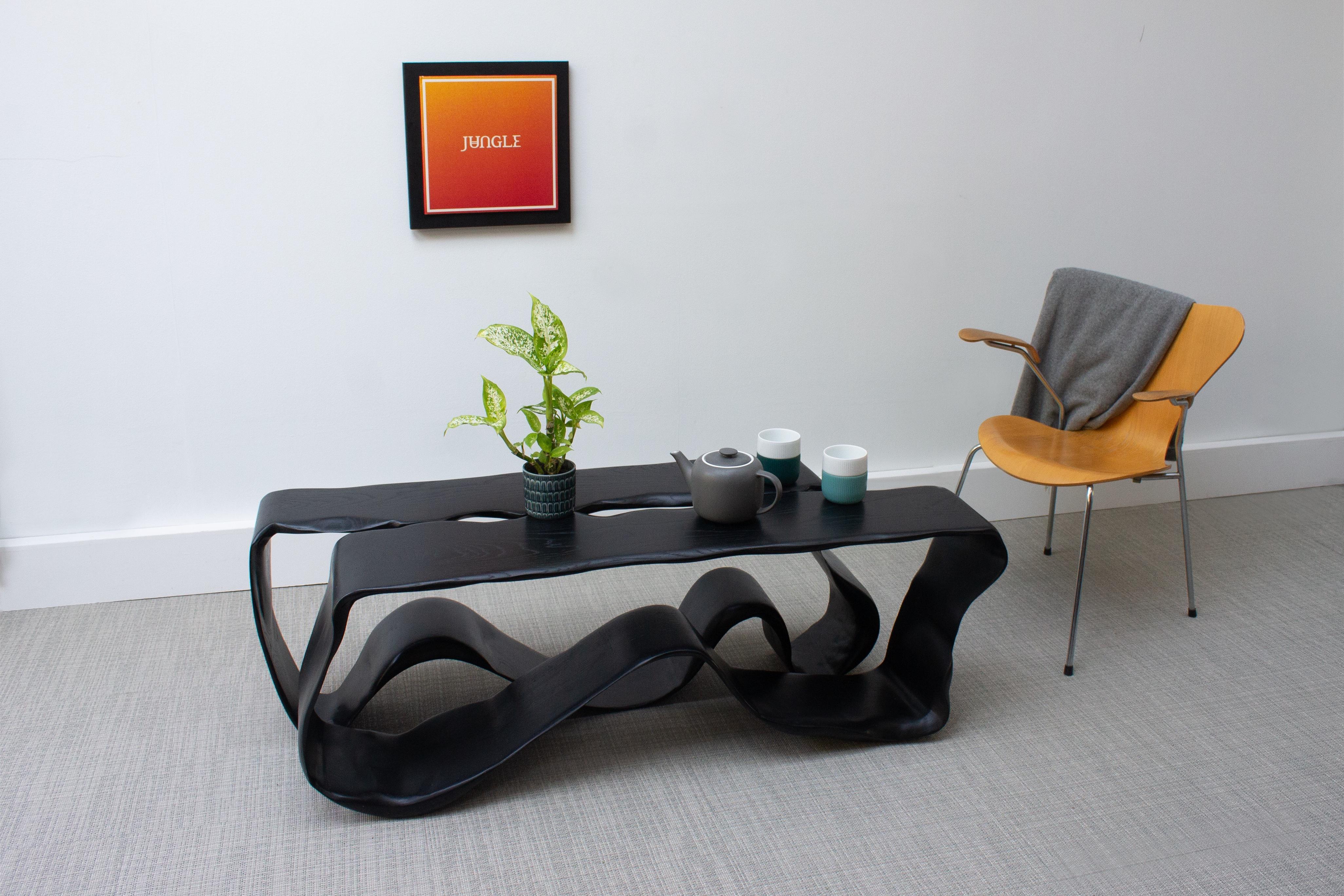 Eine neue Ergänzung zu unserer Ribbon Collection'S. Der Ribbon Low Table wurde aus Hunderten von Schichten Eschenfurnier geschnitzt, geformt und gebeizt, um diese einzigartige Formation zu erhalten.

Der skulpturale niedrige Tisch erweckt ein Gefühl