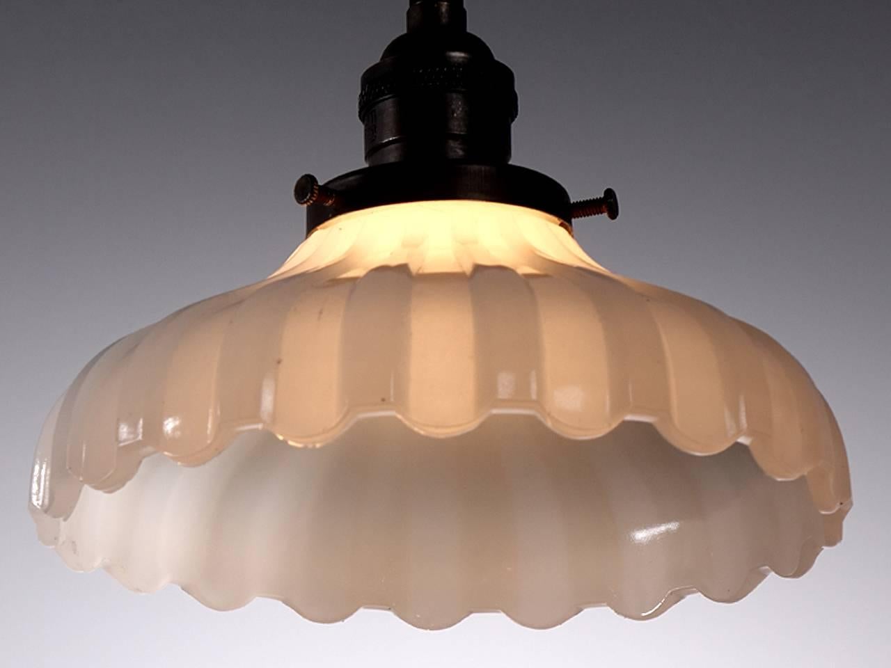Softly curved bell shaped pendants are a classic. They feel at home with any style decor. This example is an extra heavy ribbon pattern milk glass with a scalloped edge. The lamps are priced per so you can buy only one or the collection.