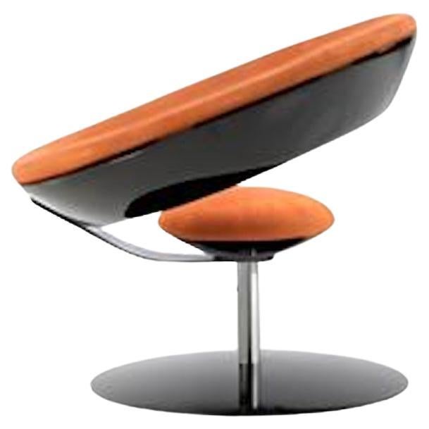 El sillón Anel es sin duda una de las creaciones más icónicas del diseñador brasileño Ricardo Fasanello.
Fabricada en fibra de vidrio y resina de poliéster, está tapizada en piel de color naranja vibrante y asentada sobre una base giratoria. Esta