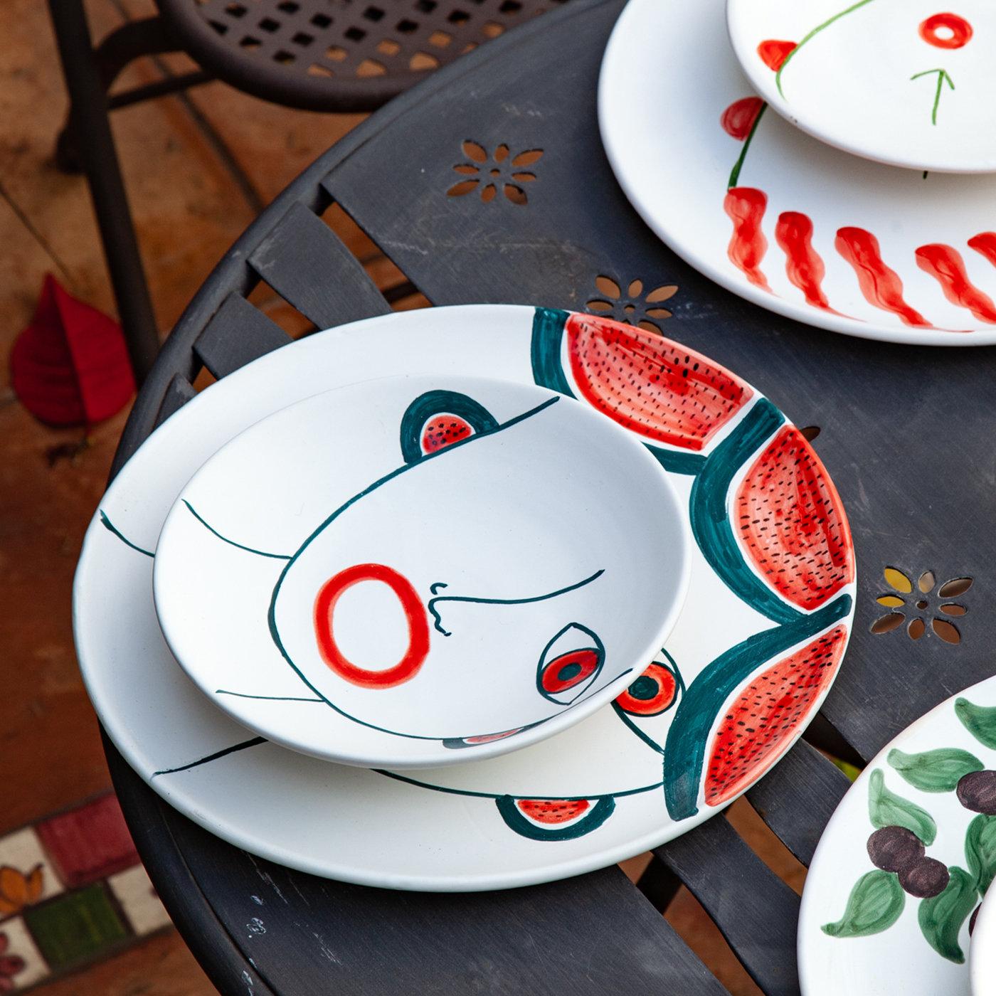 Handcrafted of matte-white-glazed ceramic and finely hand-painted by Patrizia Italiano as an homage to Sicilian local markets, this stylish and fresh set includes two dinner plates (⌀ 30 cm) and two soup plates (⌀ 18 cm) embellished with colorful