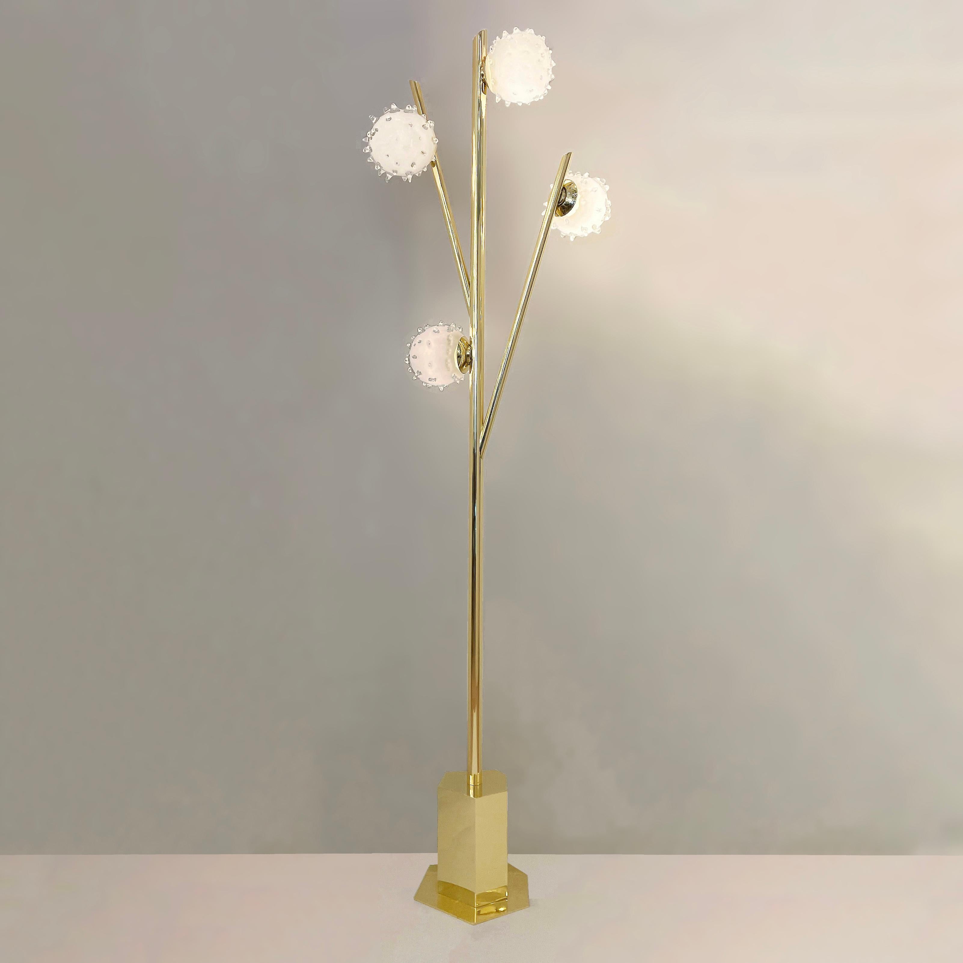 The Riccio floor lamp, inspired by nature’s variations, features a branching brass frame with four glass shades made in the rostrato technique. The asymmetrical base with its straight lines creates a harmonious contrast.  Shown in polished