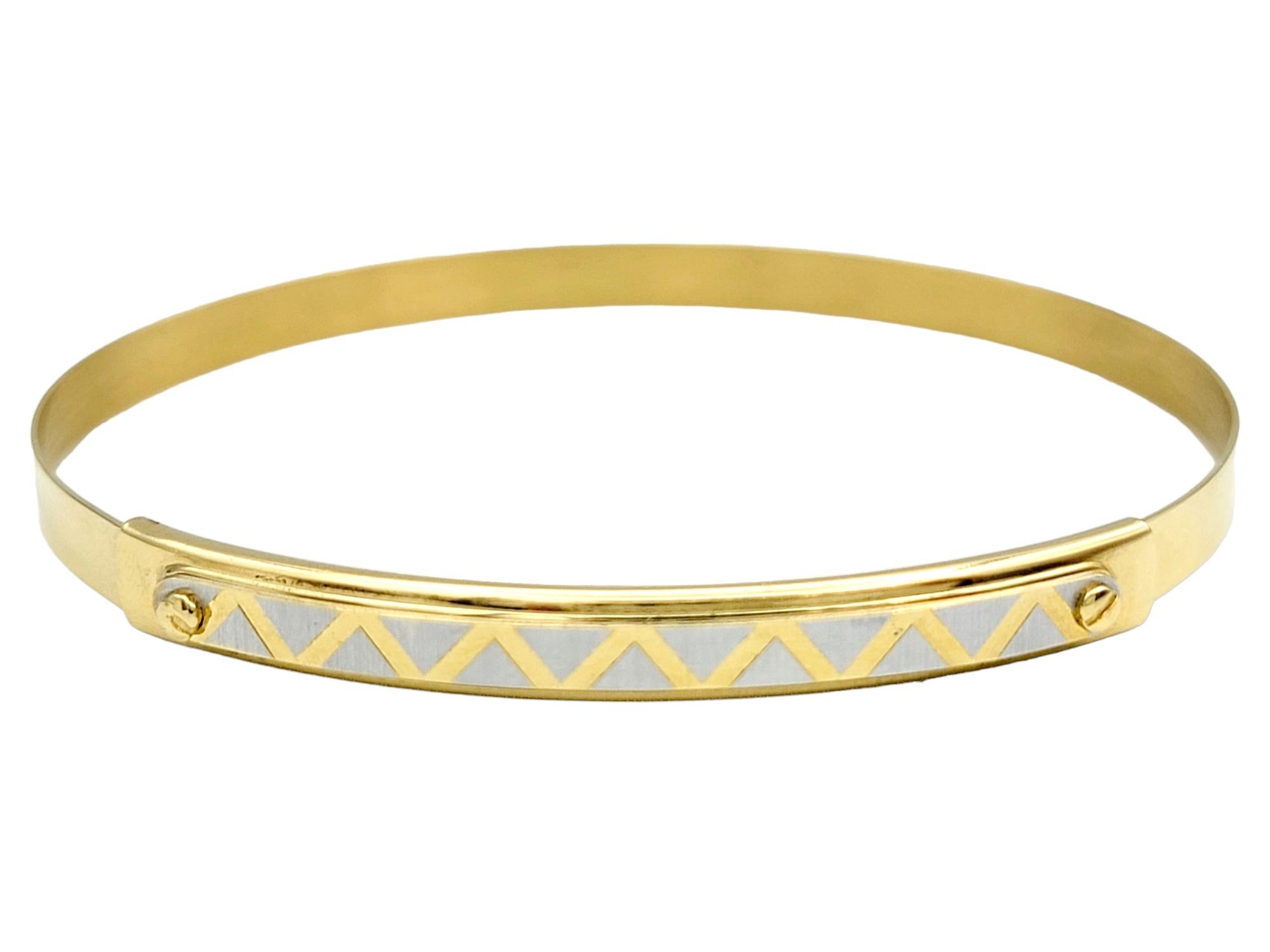 This sleek and stunning bangle bracelet, a creation by Ricciolo d'Oro, epitomizes elegance and versatility in fine jewelry. Meticulously crafted from opulent 18 karat gold, the bracelet boasts a slender and adjustable design, ensuring a perfect fit