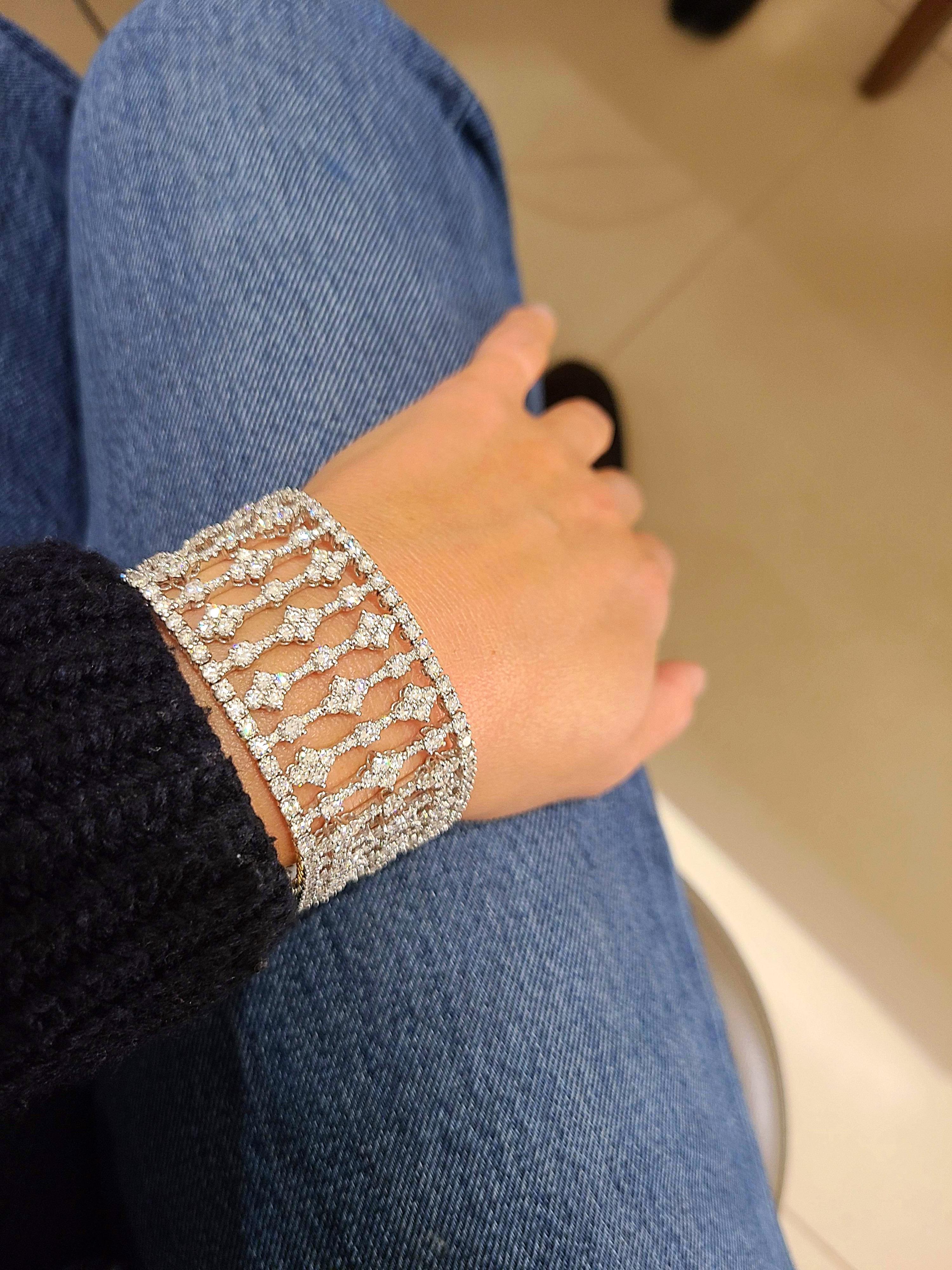 This stunning openwork bracelet is composed of 27.80 carats of round brilliant diamonds. The wide diamond bracelet is set with sections of diamonds in an elegant pattern that floats beautifully on the wrist as a cuff bracelet. The bracelet is 1.25