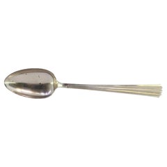 Rice spoon and serving dish in silver with grooves along the handle