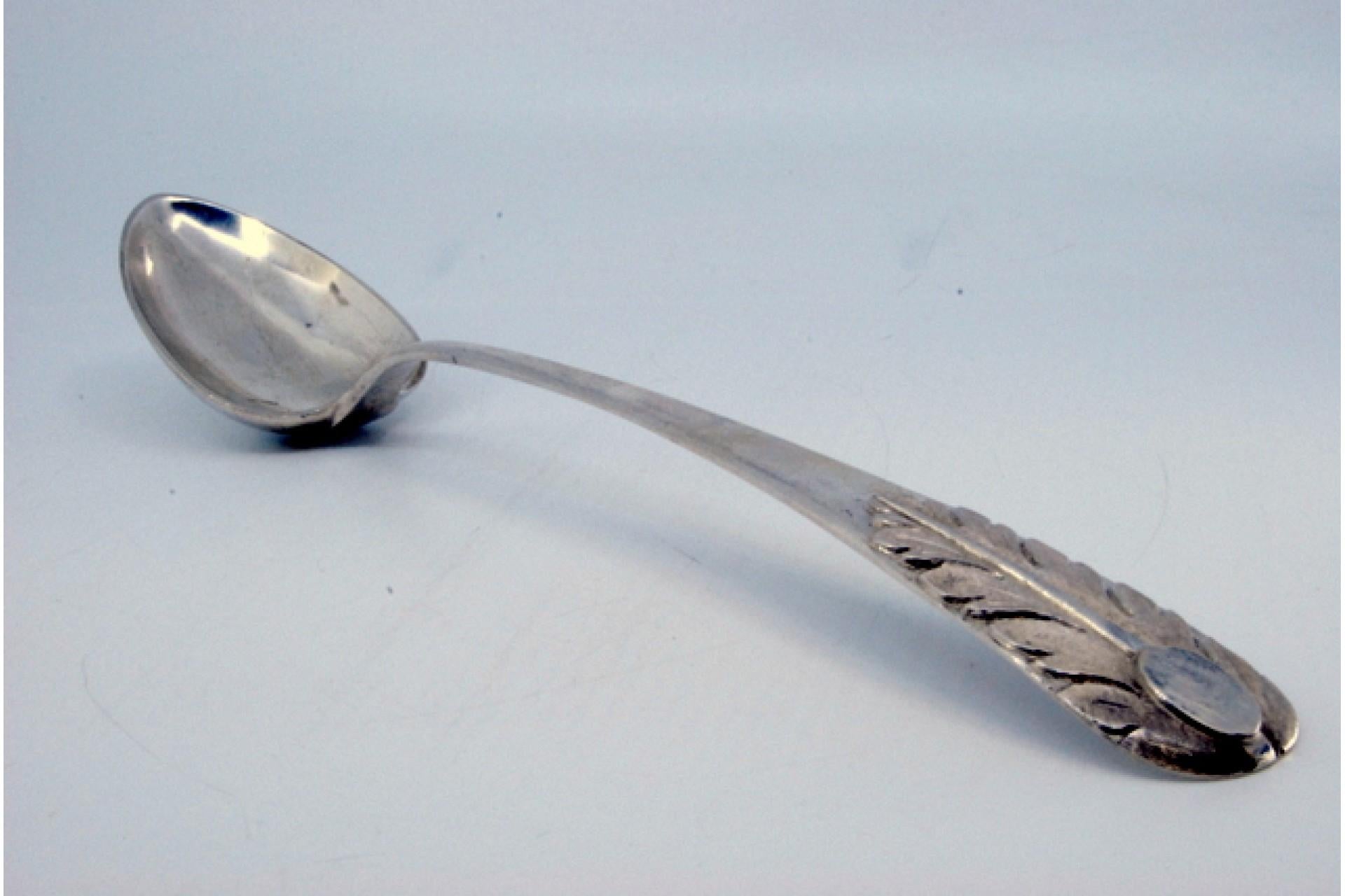 Descripción: Cuchara arrocera y de servir de plata con hojas de acanto grabadas en el mango. Metal: Silver. Origen: Portugués. Marca: Porto Coroa. Peso: 148,53 gramos. Dimensiones: 30,5x5,5 cm. Contenido: 833/1000. Marca de ensaye: Sí, desde el