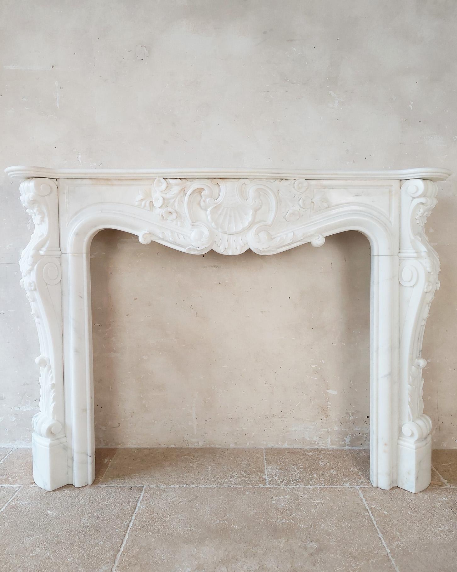Rich 19th century Trois coquilles mantelpiece made of very white statuary quality bianco carrara marble. The front and the entire styles of this fireplace have coquilles and flower decorations.

h 107 x w 145 x d 35 cm
opening: h 80 x w 94 cm