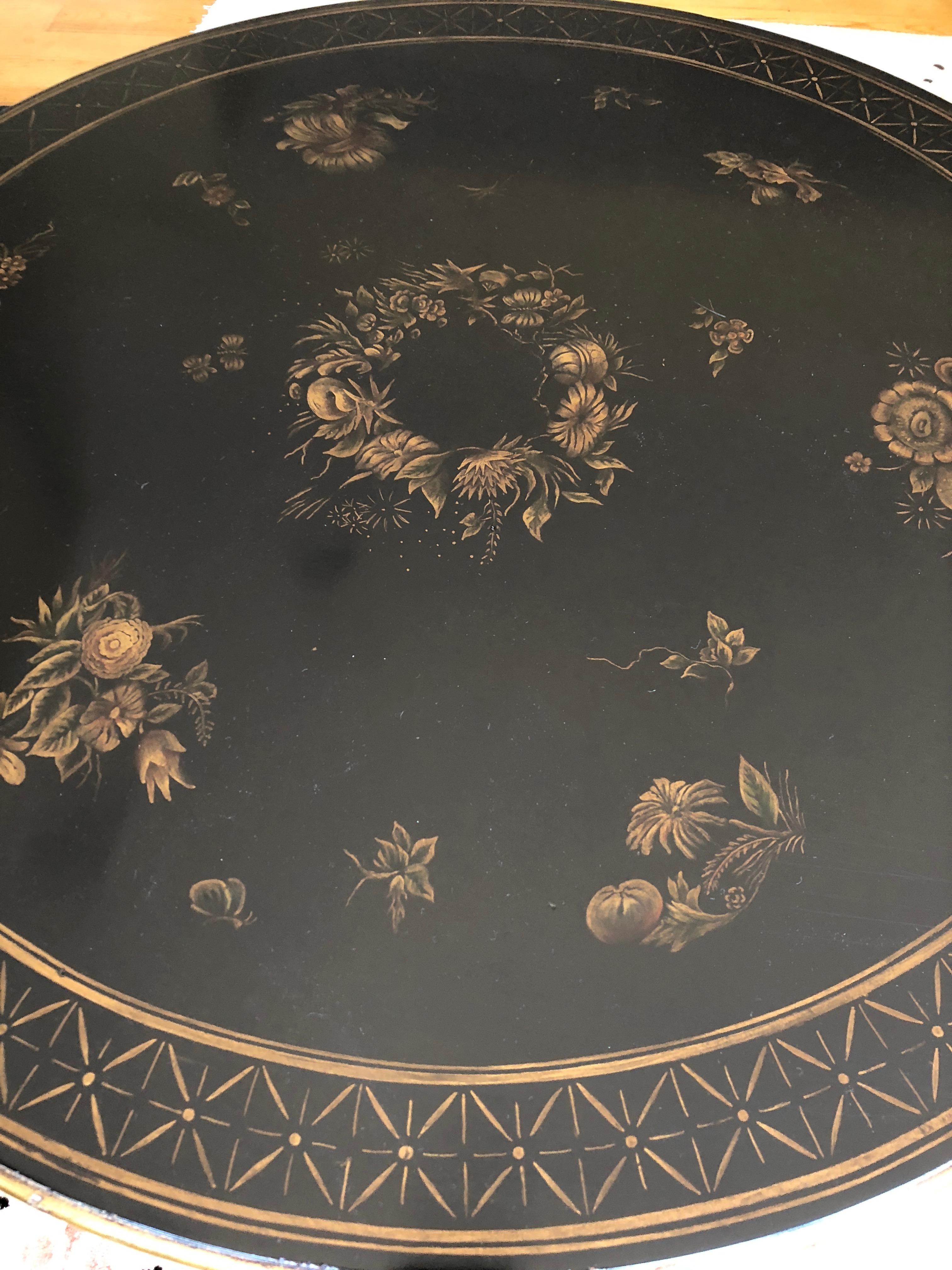 Rich looking black round side or centre table having gold hand painted decoration and beautiful gold balls around the bottom periphery of table and handsome paw feet.