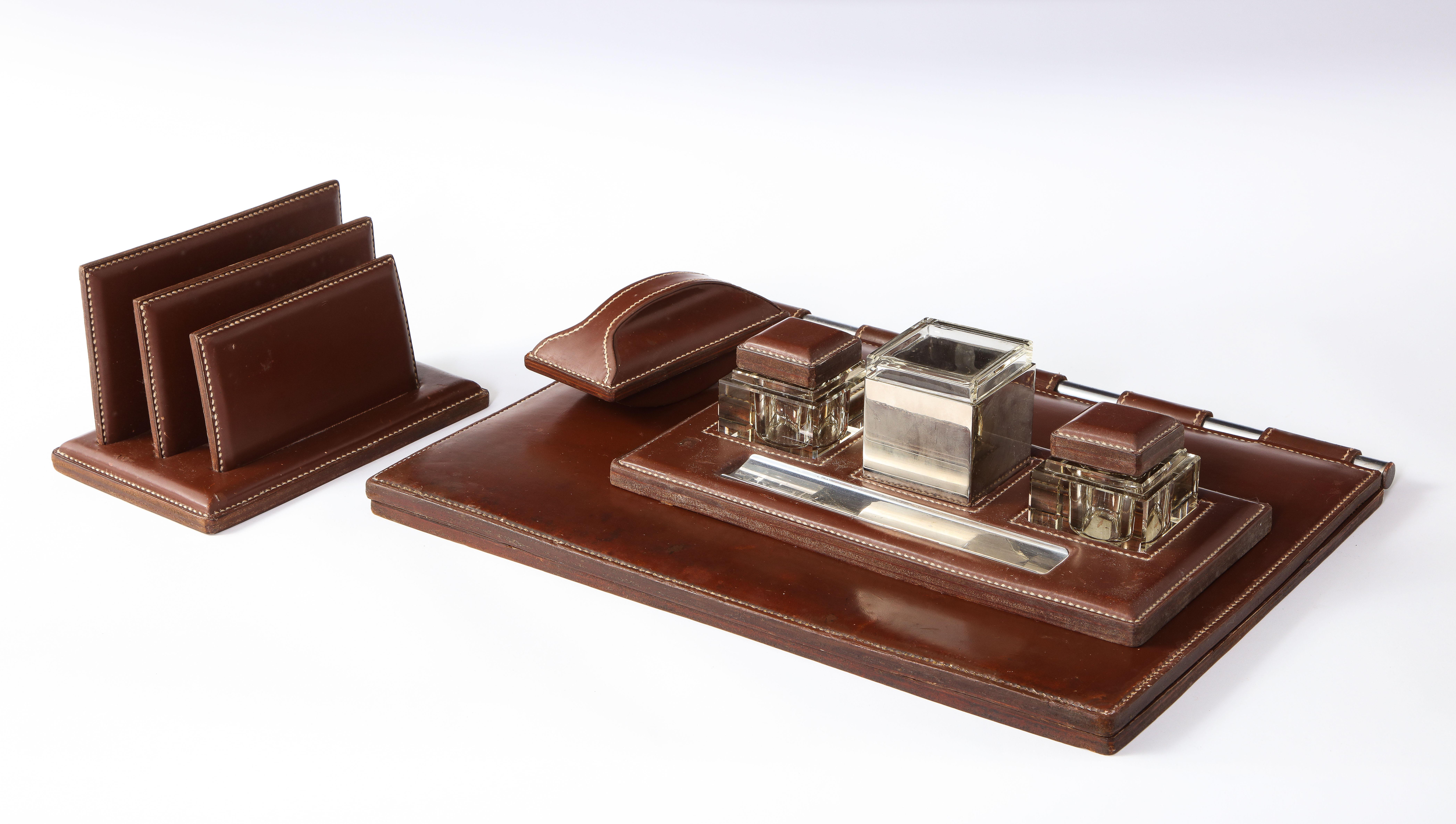 A desk set by Adnet, comprises a complete inkwell, an ink blotter, a letters holder and a desk mat that opens up and can be fitted with writing paper. In excellent vintage condition.